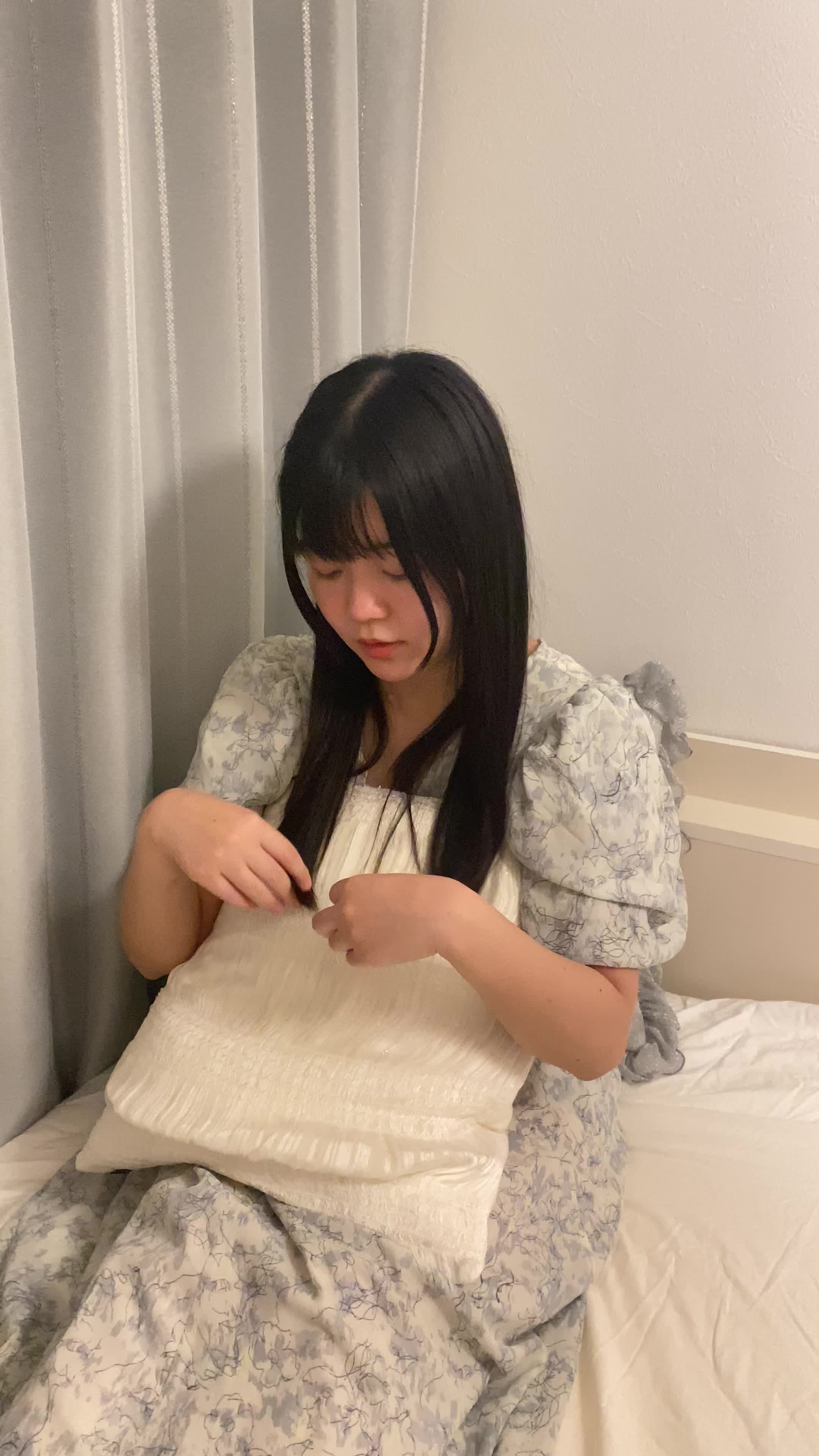 ベッドでクッションを抱きしめ、「髪がまとまったらどんな気分だろう」と期待に胸を膨らませる姿