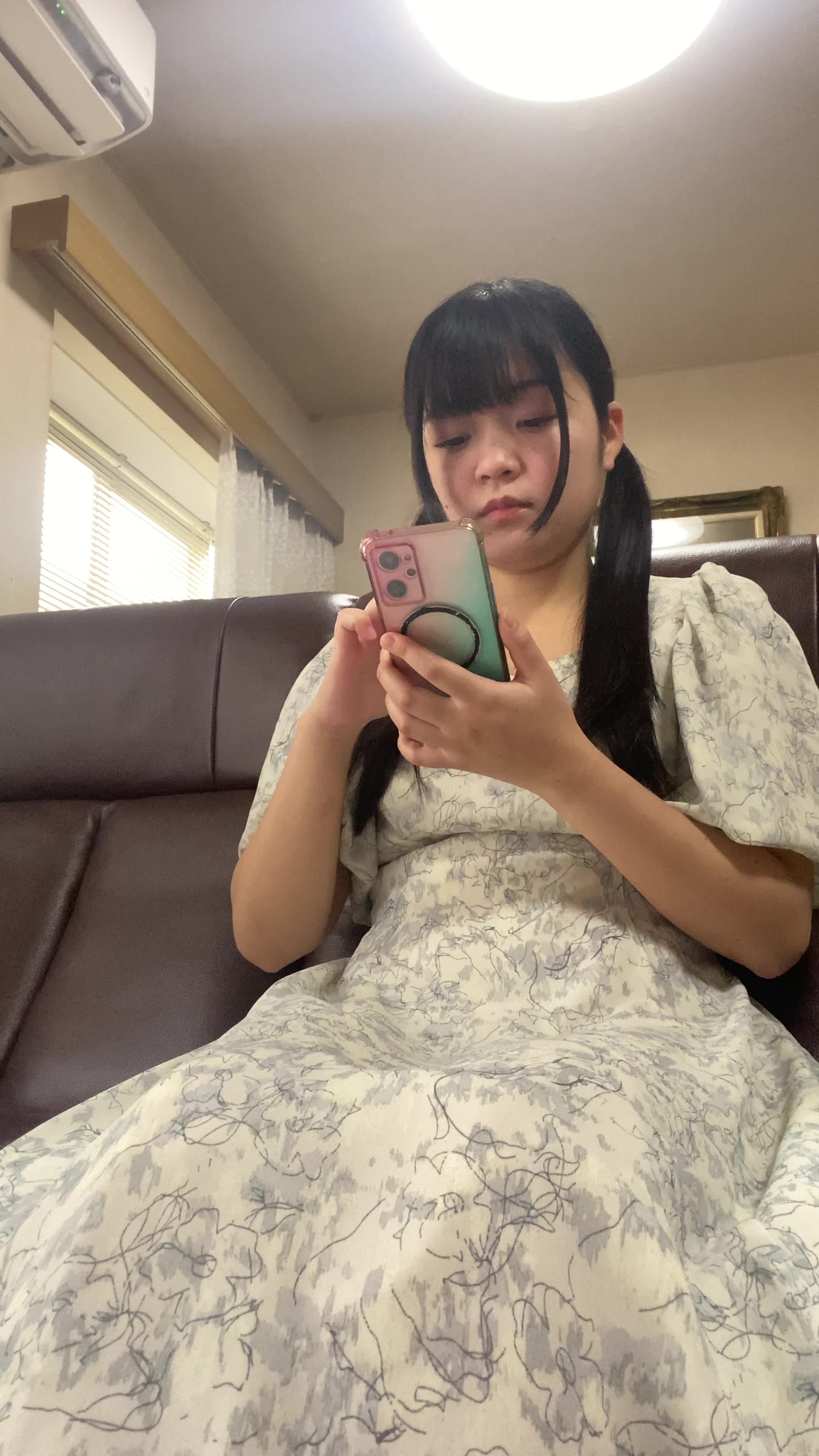 ソファでスマホを見ながら、「ウォーターサーバーってどうなんだろう？」と検索する様子