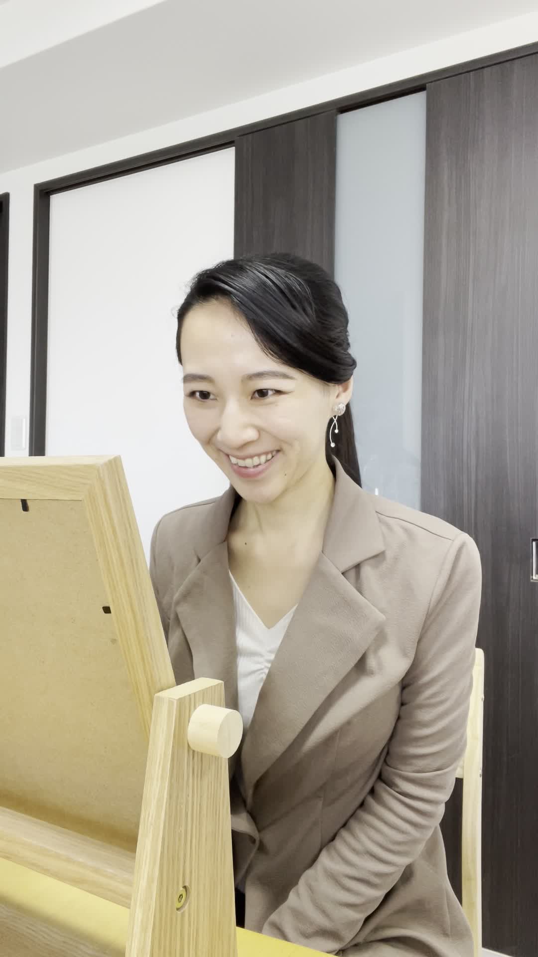 鏡の前で笑顔を作り、「自信がついたら新しい挑戦ができるかも」と期待する顔