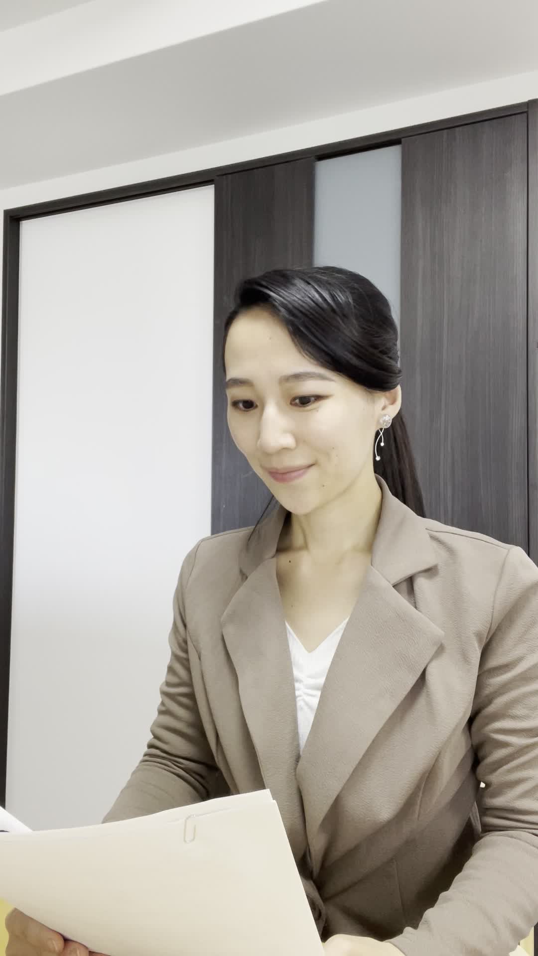 テーブルで書類を整理しながら、「これが新しい私への第一歩」と微笑む姿