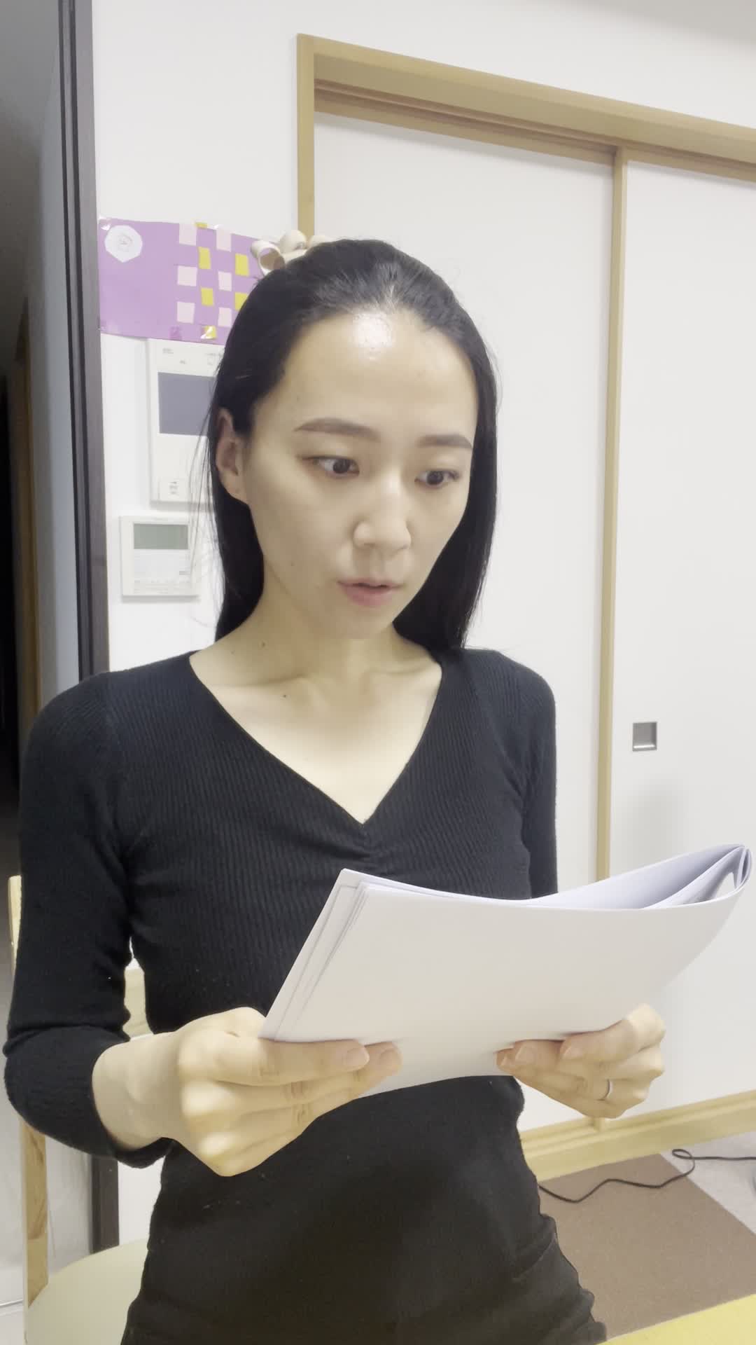 テーブルで紙を見つめ、「次の一手を決めた」風の自信を見せる表情