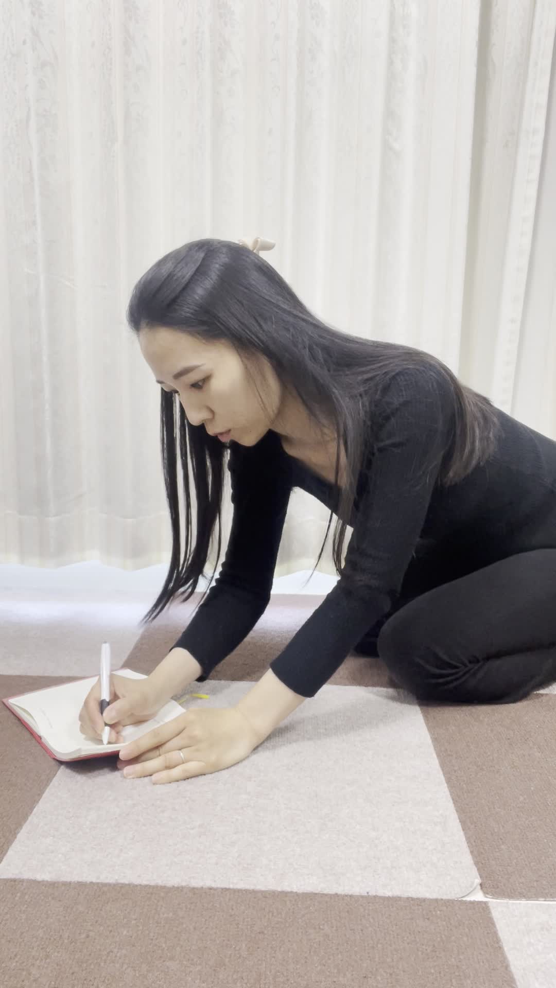 床にノートとペンを広げ、真剣に目標をリストアップする様子を映すシーン