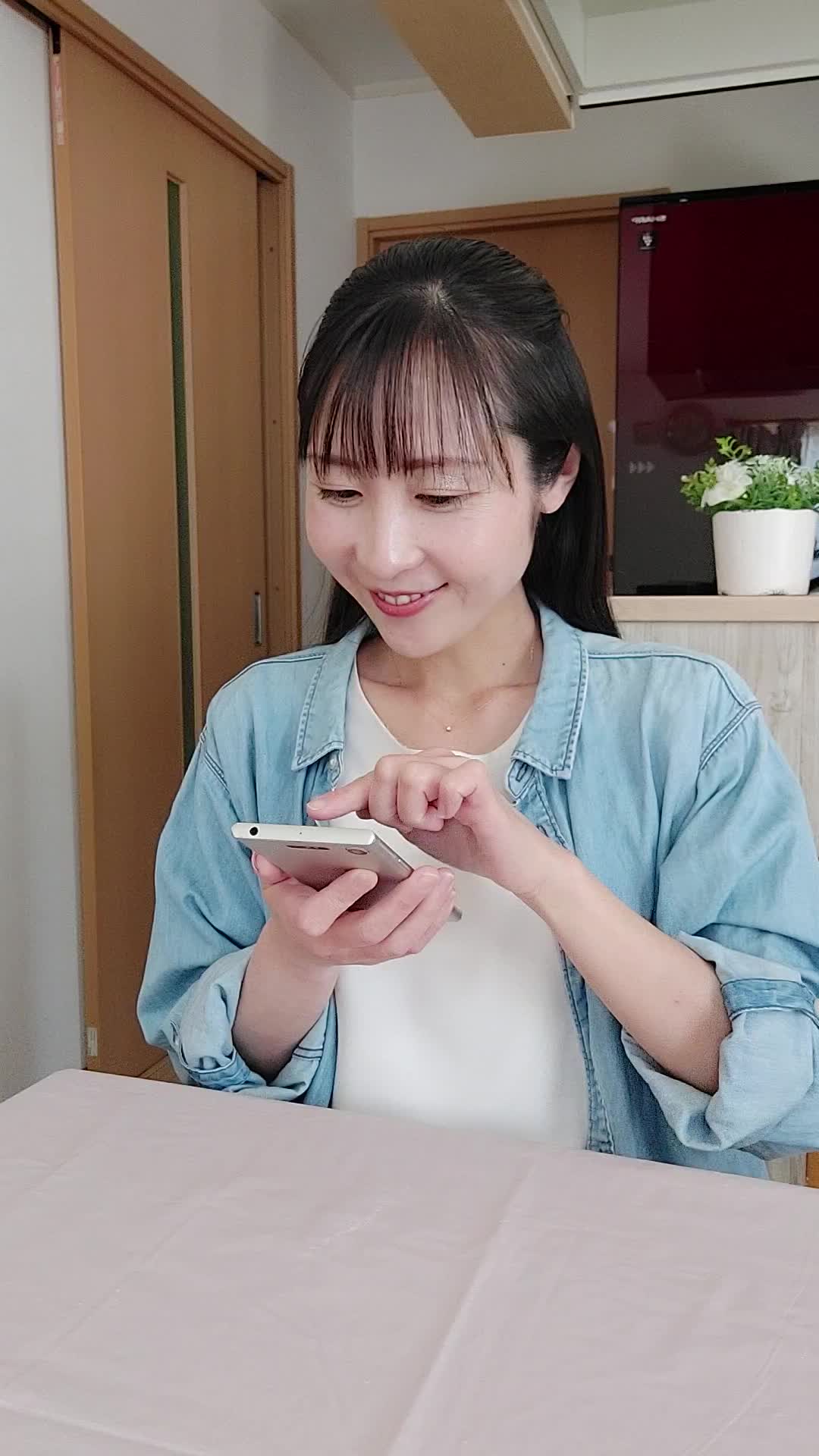 椅子に浅く腰掛け、「クーポンを適用してさらにお得に」とスマホを操作する姿