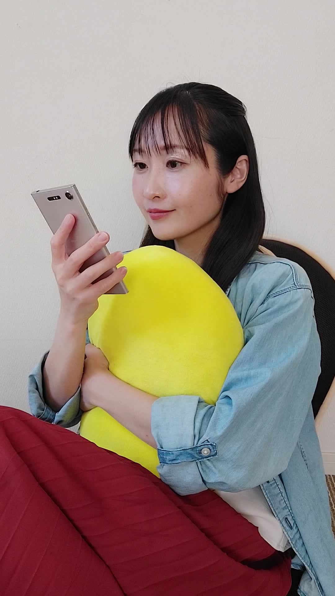 ソファでクッションを抱え、スマホの画面を見て「これがタイムセール価格？」と驚く様子