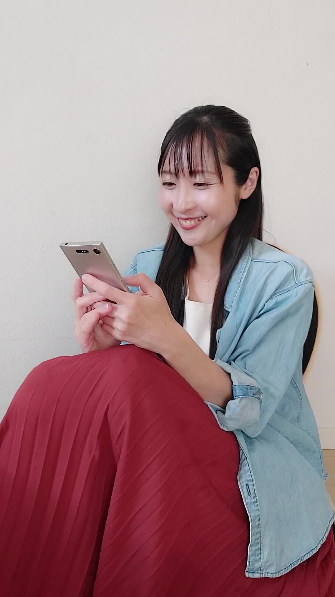 ソファで友達と話しながら、「これが新作だよね！」と嬉しそうに見せる姿