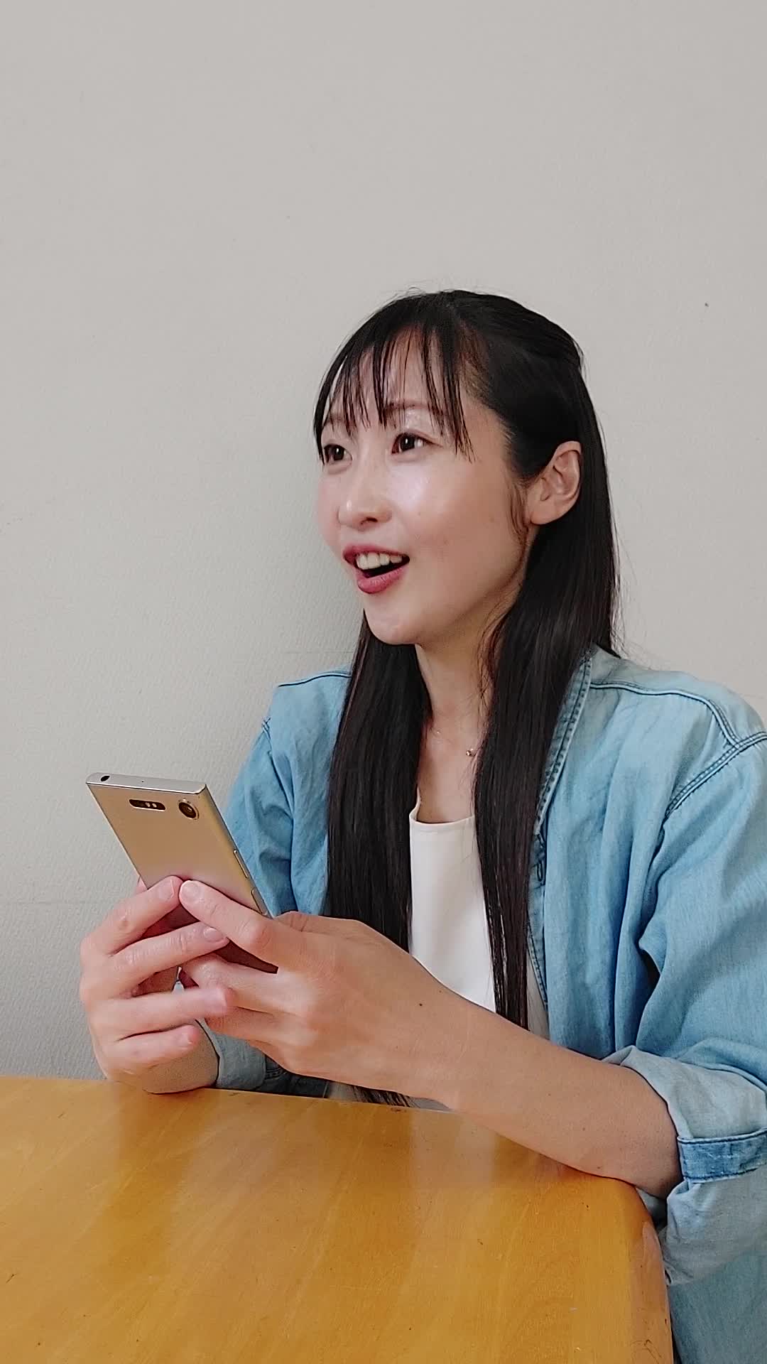 ソファでスマホを見ながら、「友達におすすめアイテムを共有する」楽しそうな表情