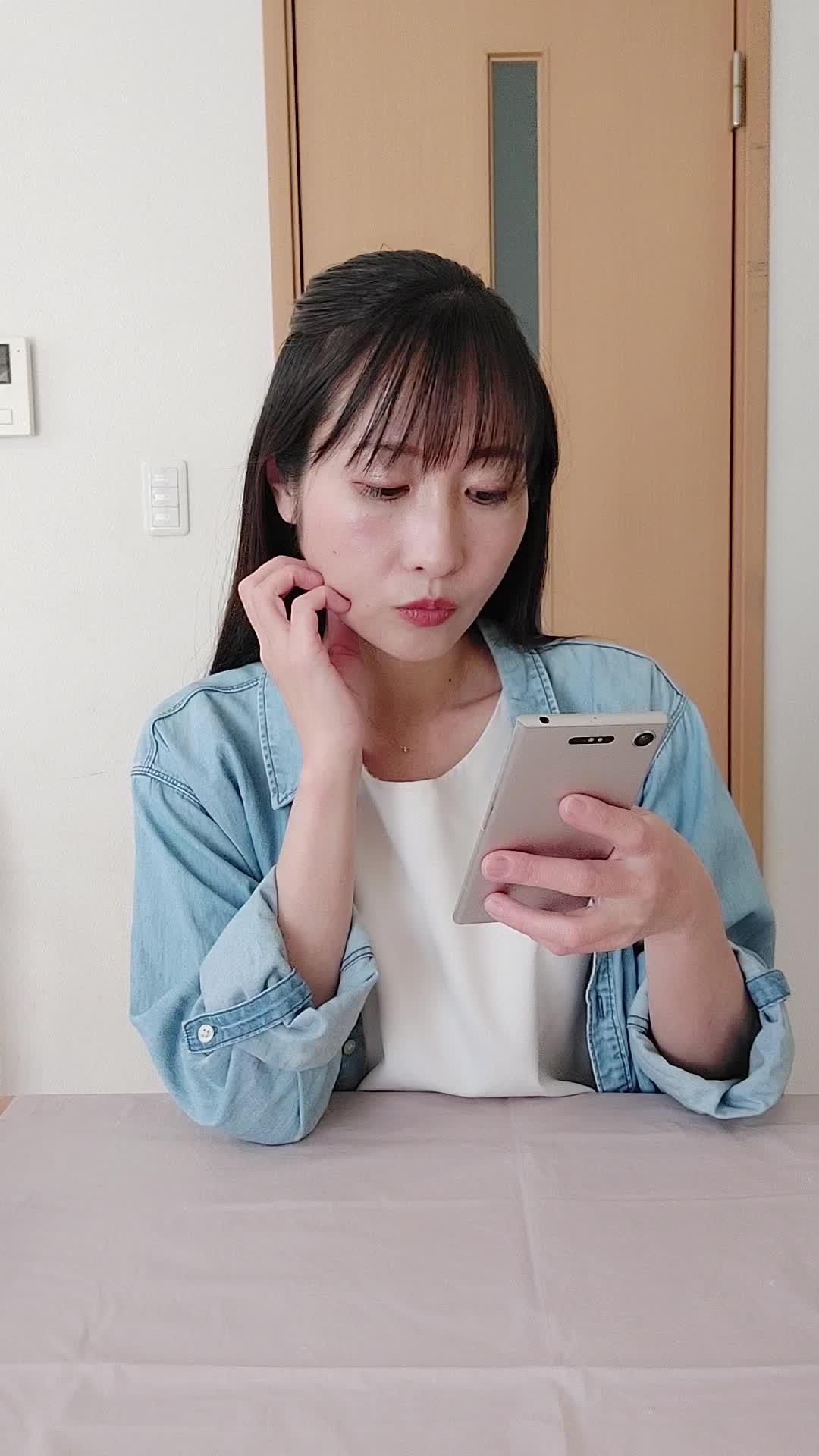 テーブルでスマホを操作しながら、「レビューを読んで納得する」真剣な表情