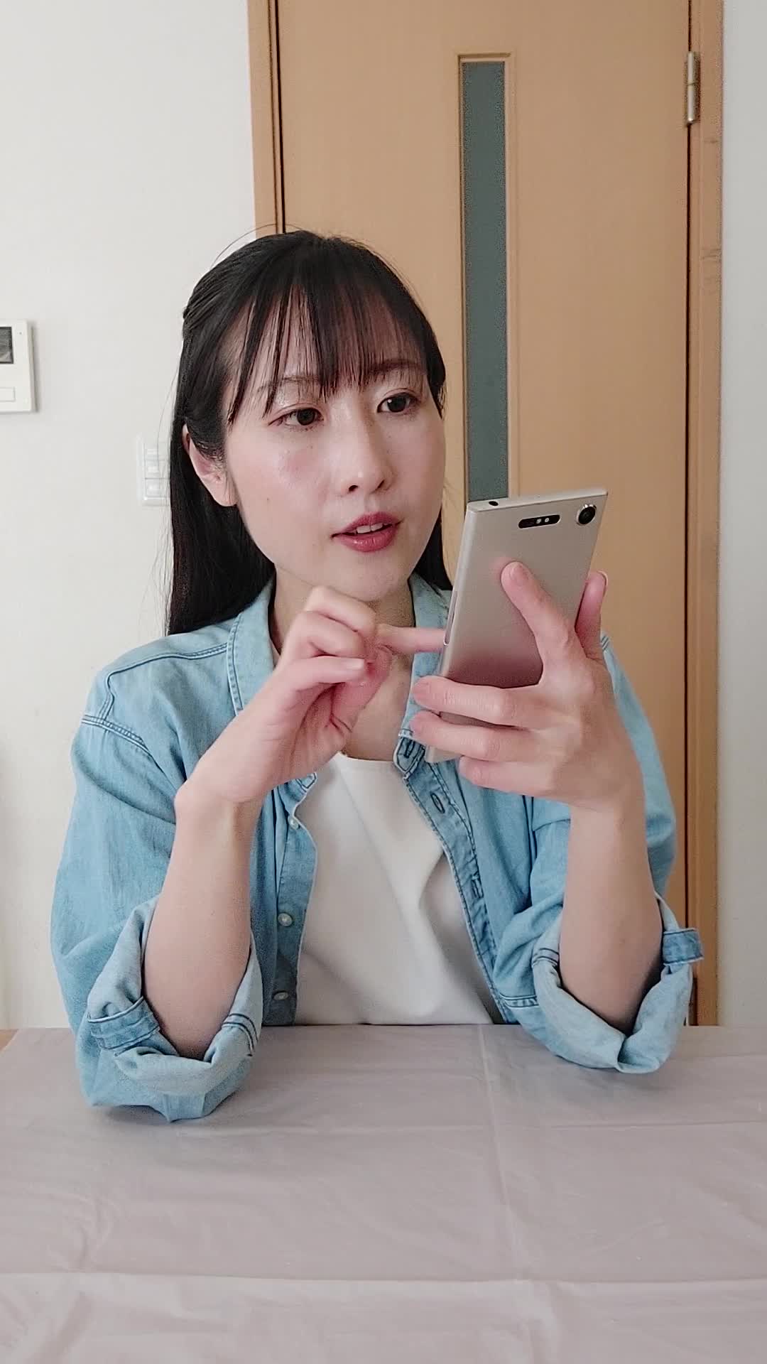 テーブルでスマホを操作し、「注文履歴を見て再注文を考える」真剣な表情