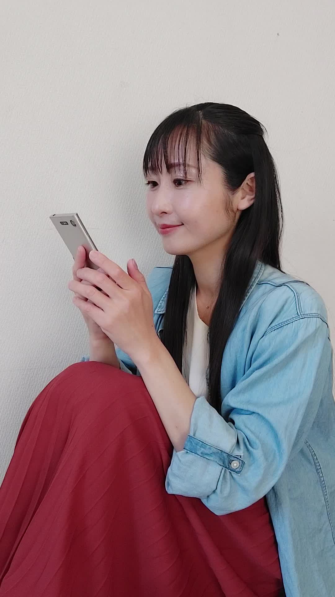 床に座り、「注文完了画面を見て達成感を感じる」笑顔を浮かべる様子