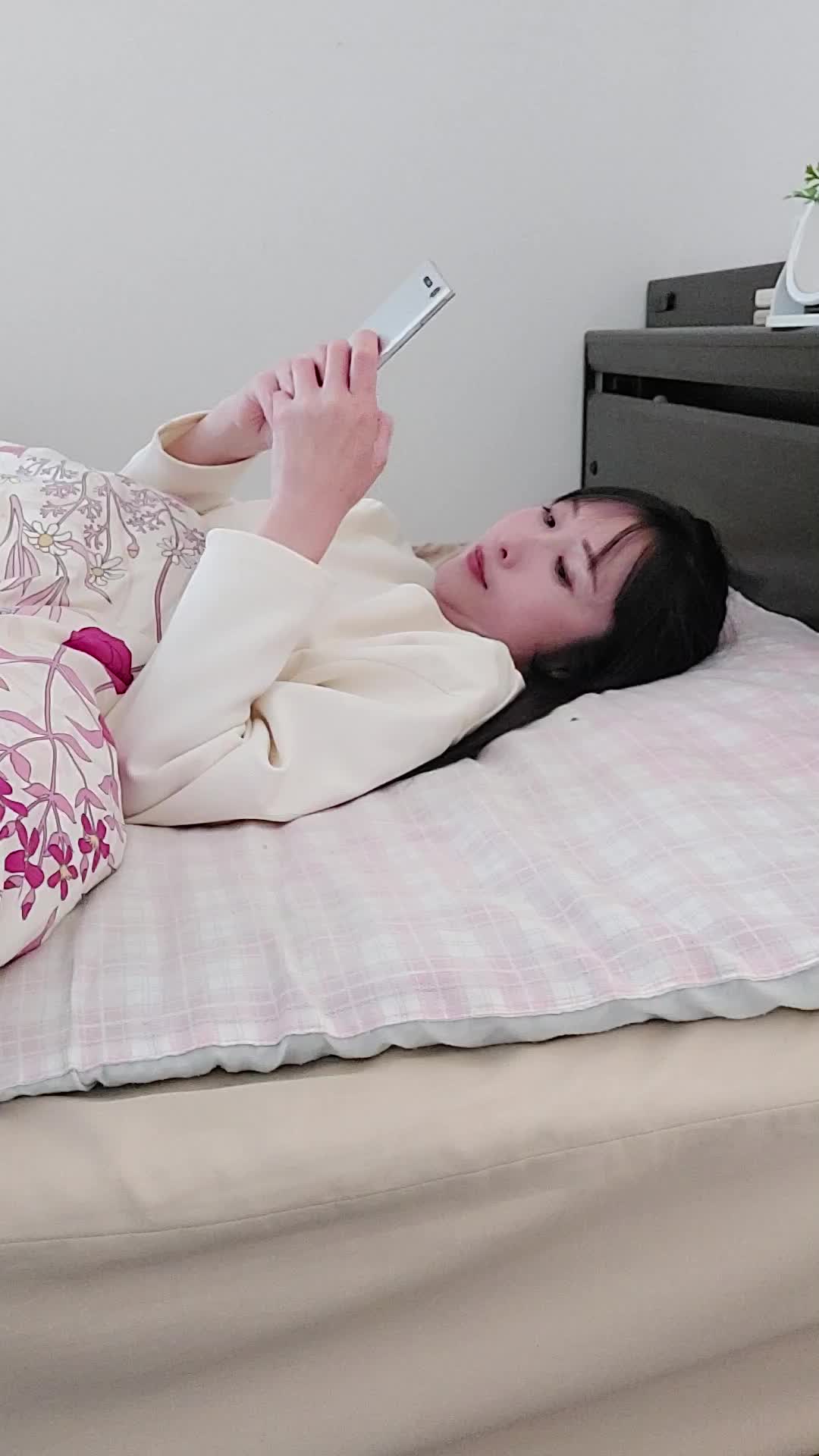 ベッドで横になり、「夜中に気になる商品を検索してしまう」楽しそうな表情