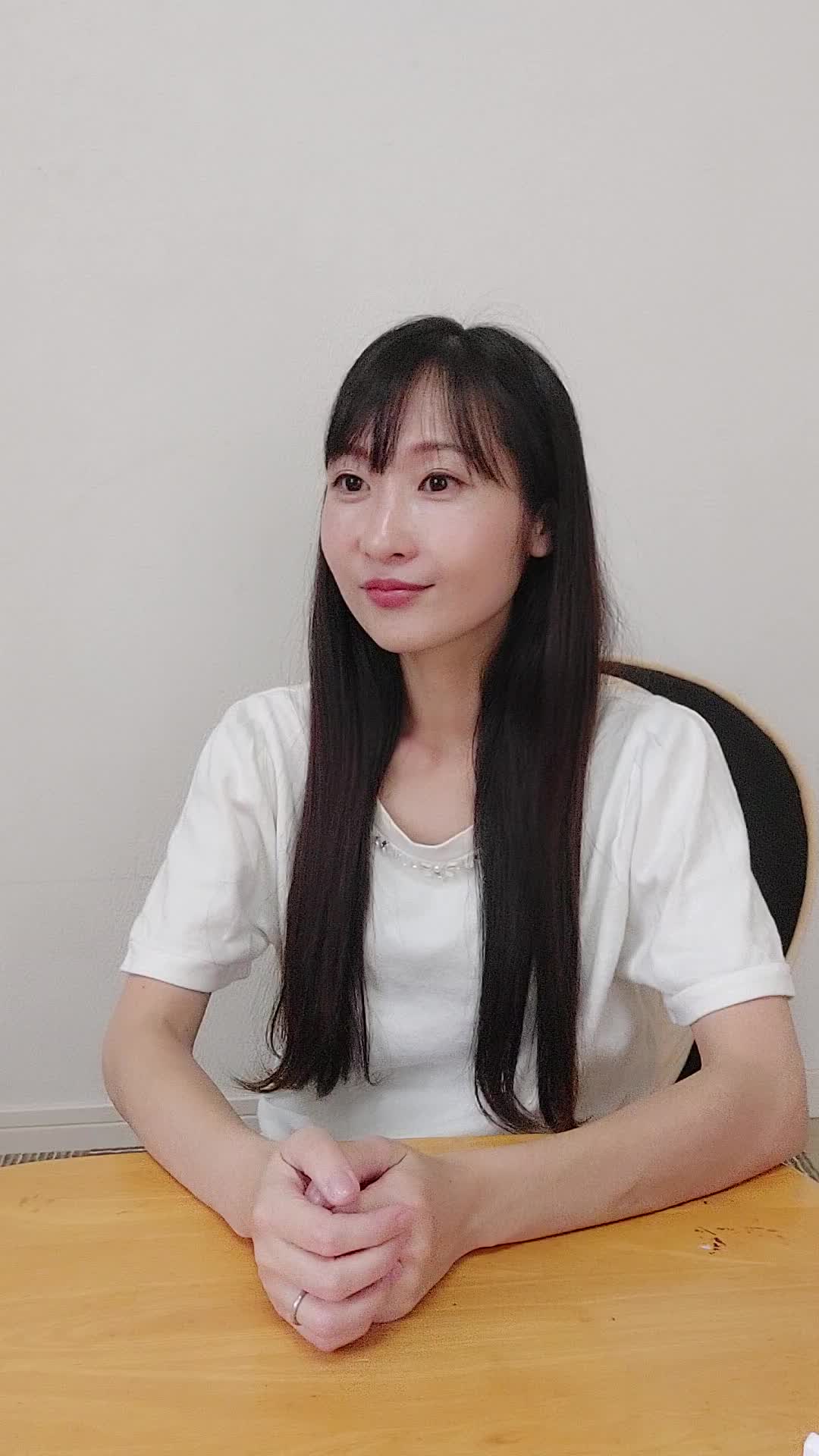 ソファで友達と話しながら、「白髪が気にならないヘアスタイルを聞いている」姿