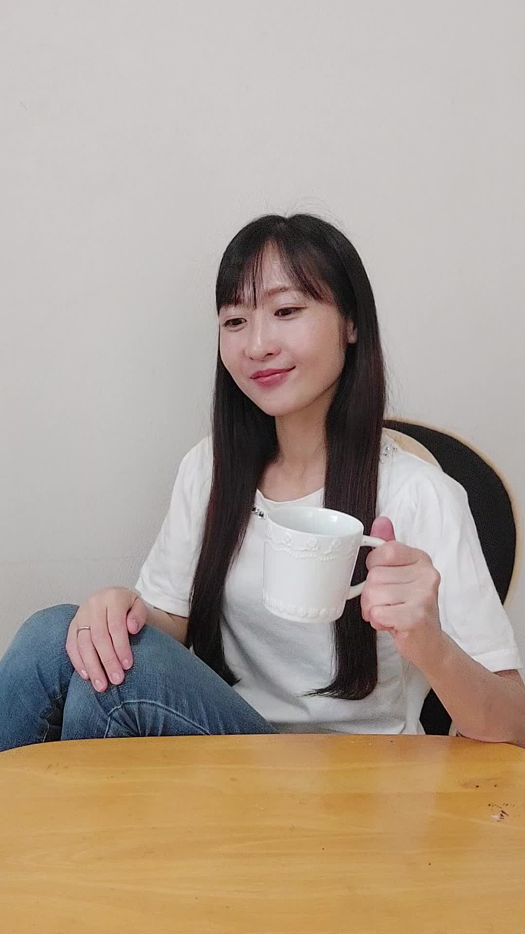 ソファでカップを手に、「次の白髪ケア商品を試す楽しみ」を思い浮かべる表情