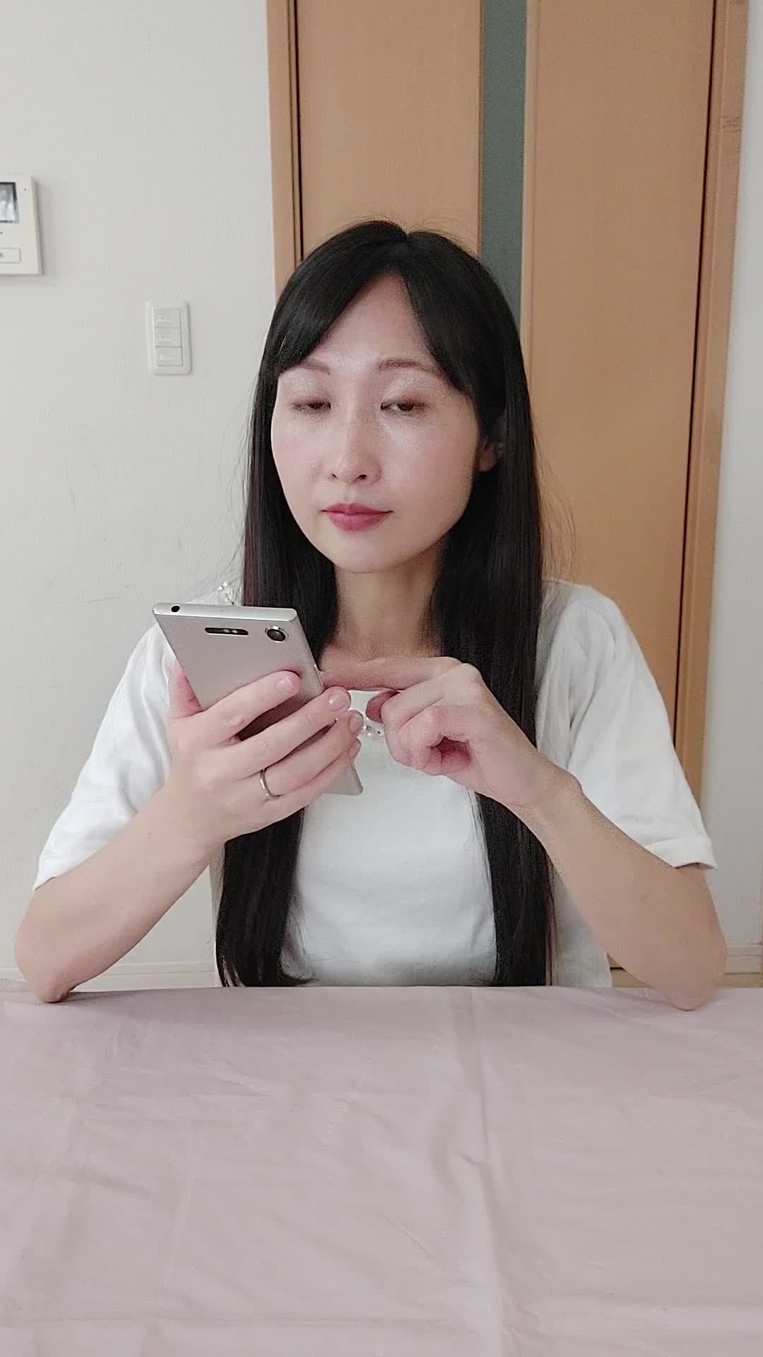 テーブルでスマホを操作しながら、「白髪ケアの商品を調べる」集中した表情