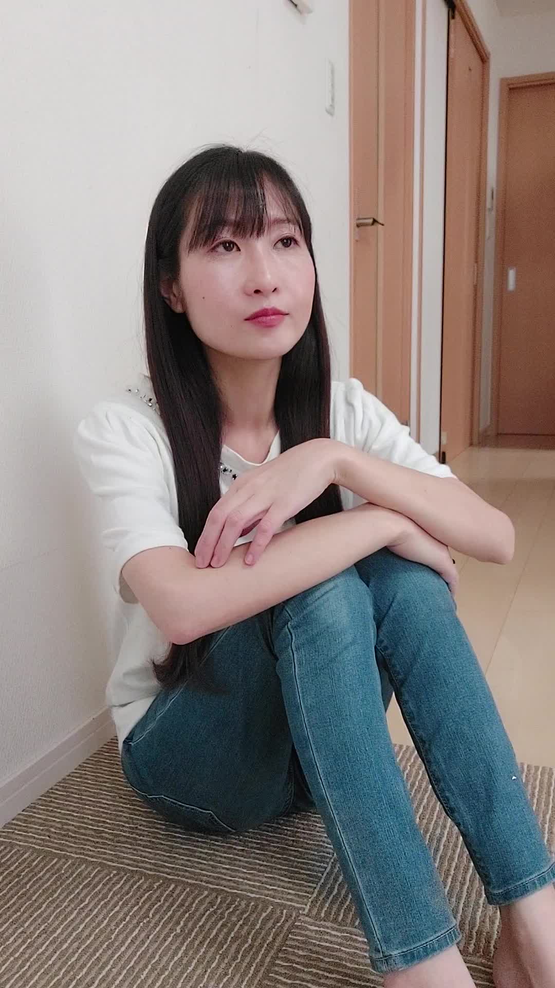 床で膝を立てて座り、「この白髪ケア商品を試してみようかな」と期待を込める動作