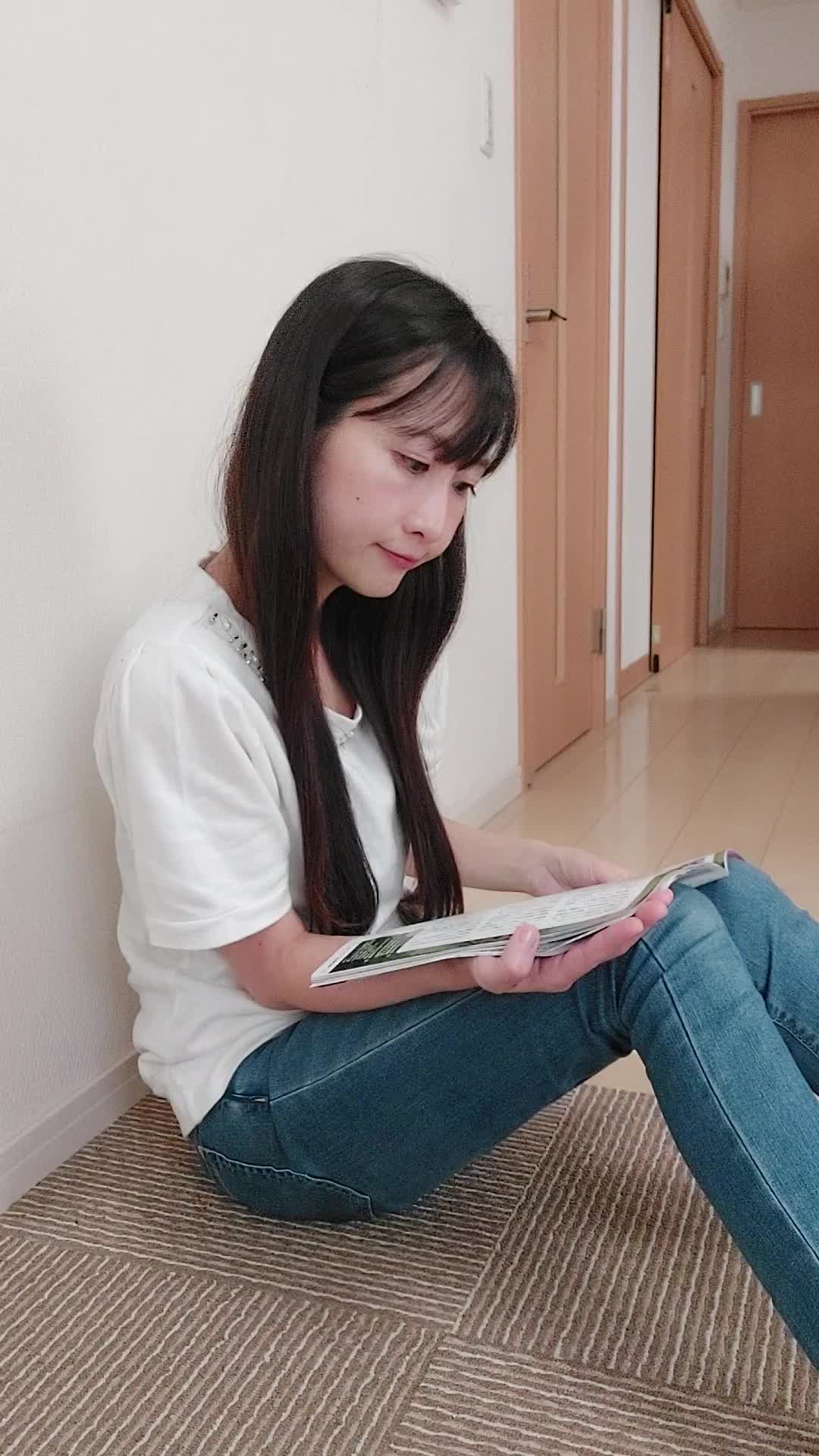 床でカタログを眺め、「白髪ケアの商品をじっくり選んでいる」様子