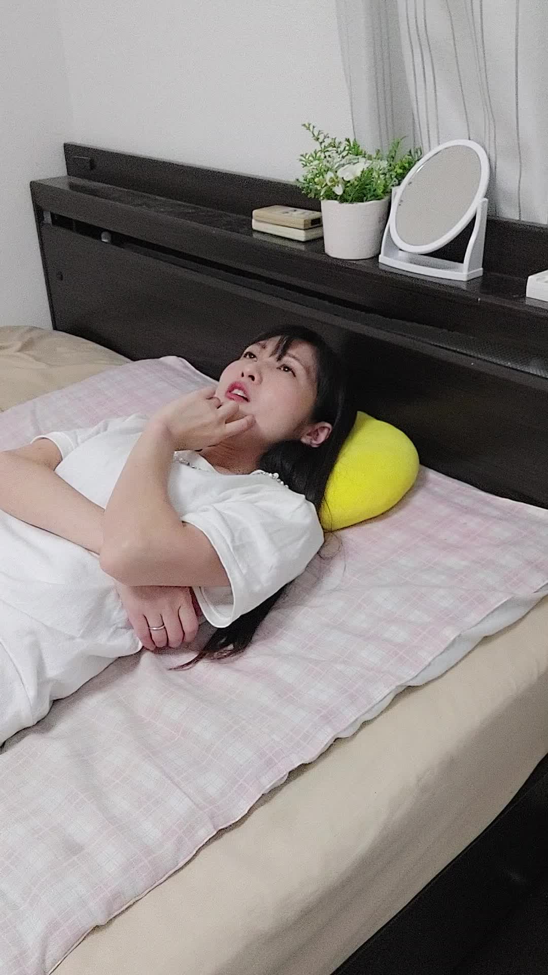 ベッドで横になり、「これ以上白髪が増えたらどうしよう」と不安そうに考える姿