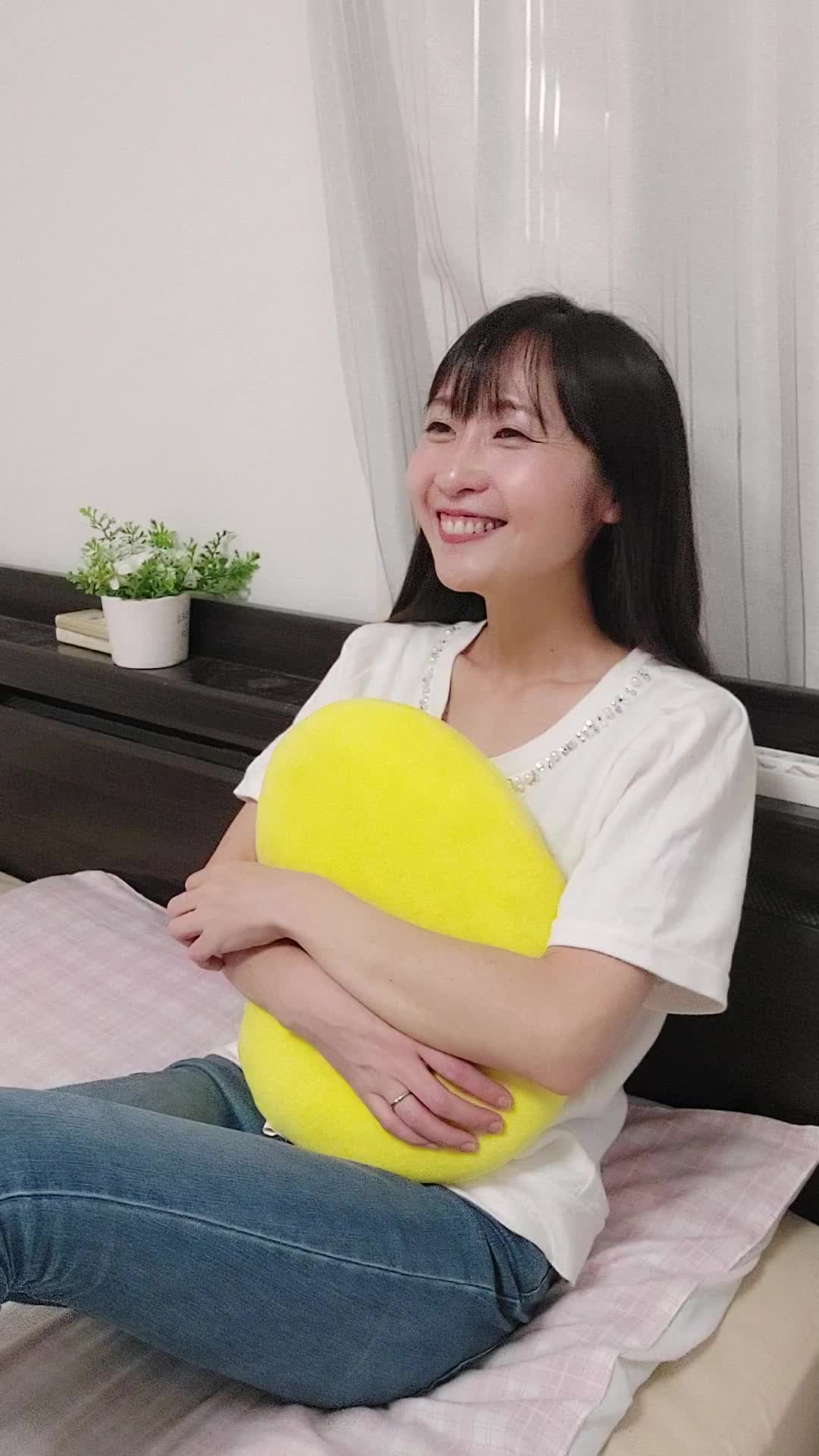 ベッドでクッションを抱えて、「白髪がなくなったらこんなことがしたい」と夢見る表情