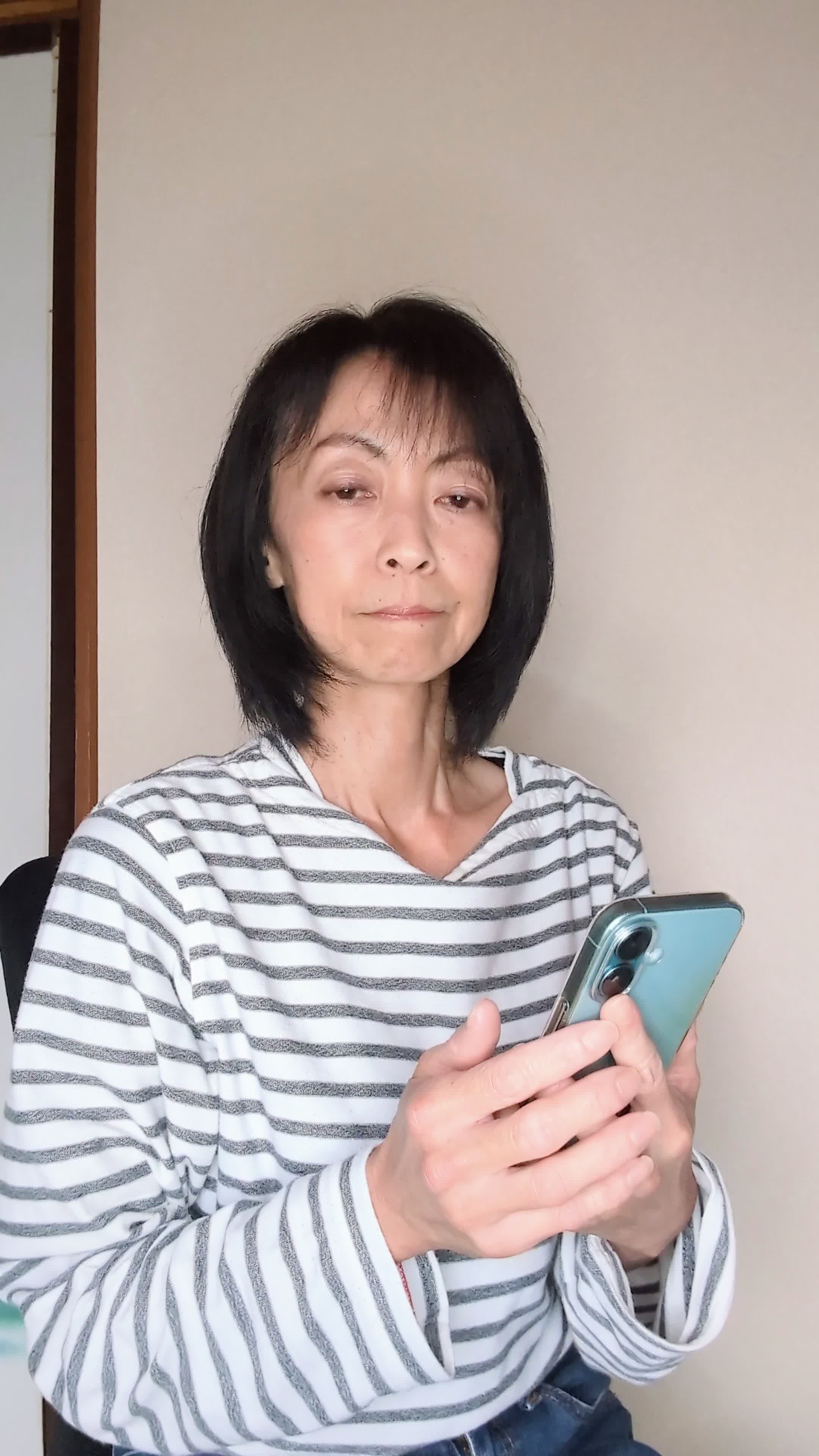 椅子に腰掛け、スマホの画面を見ながら「仕事頑張ろう！」と気合を入れる動作