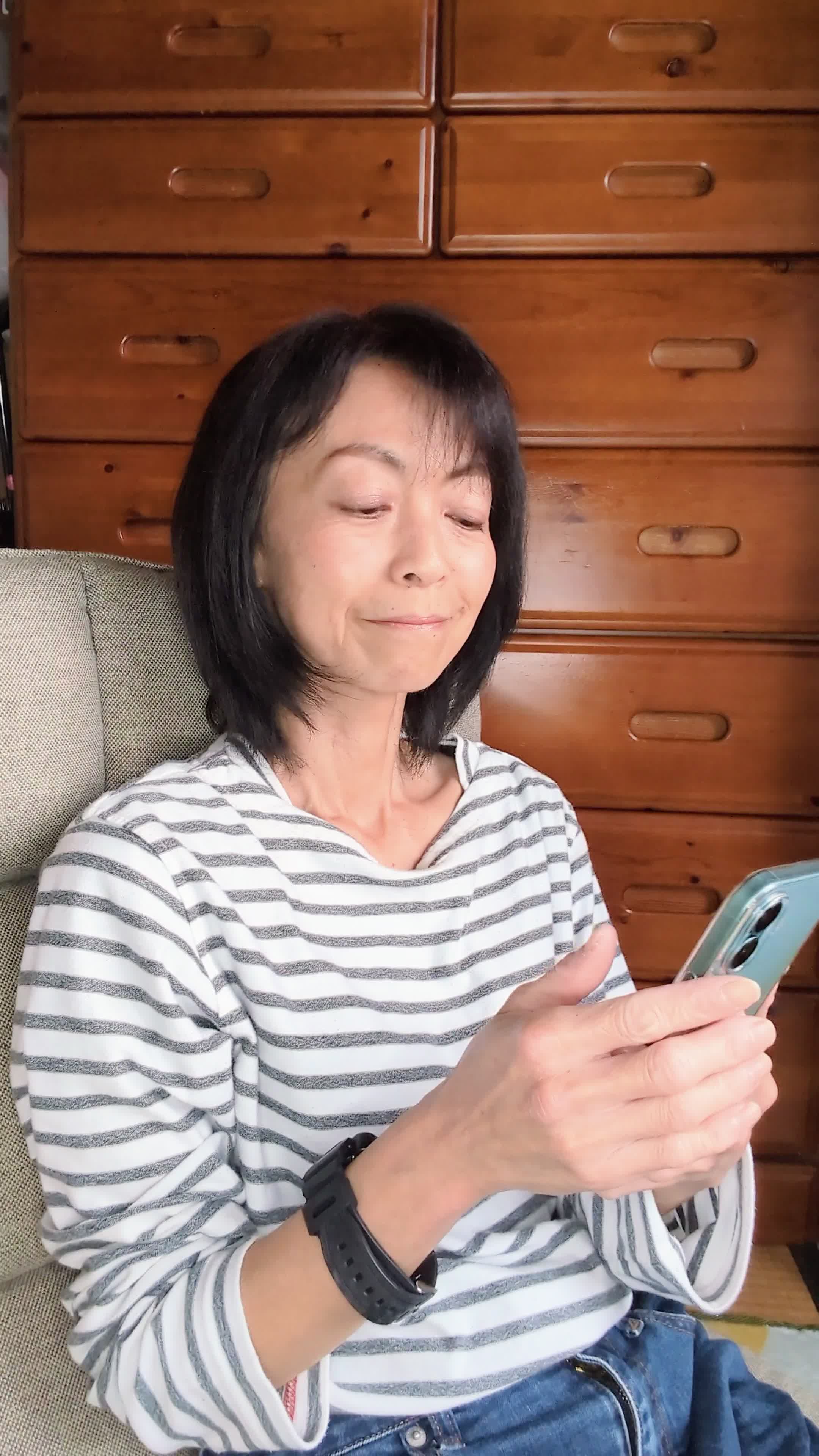 ソファで、「1エピソードだけのつもりがこんな時間に！」と少し焦る表情