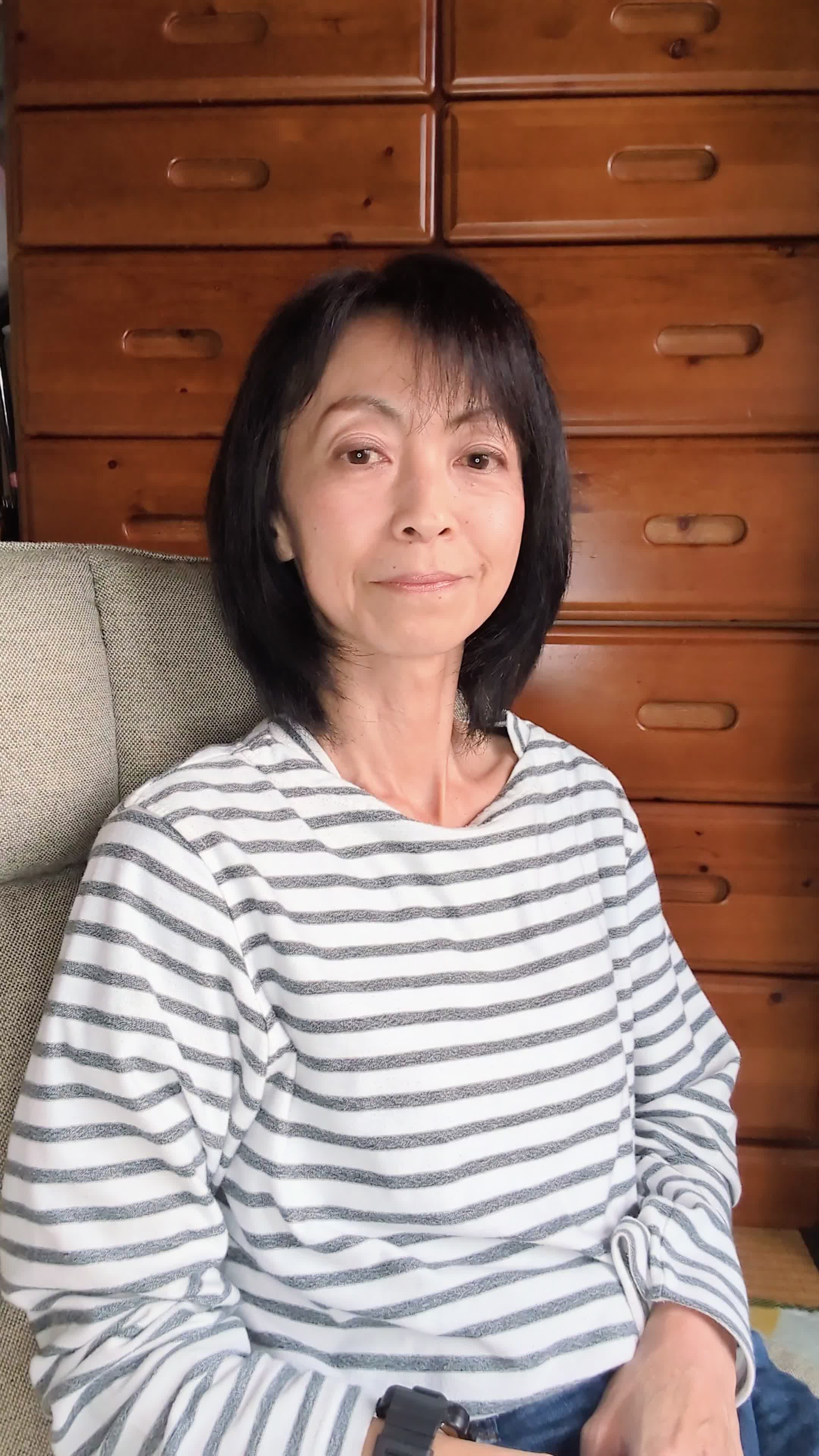 ソファで時計を見ながら、「次の配信時間まであと少し！」と期待で胸を膨らませる表情