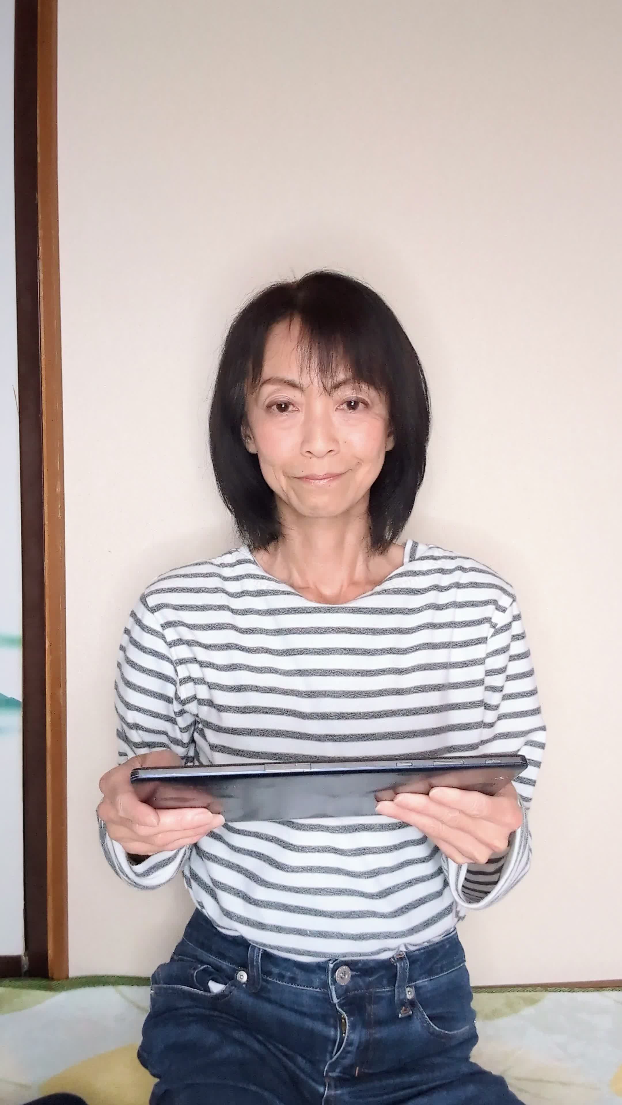 床でタブレットを操作しながら、「これ、友達にも勧めたい！」と笑顔を浮かべる様子