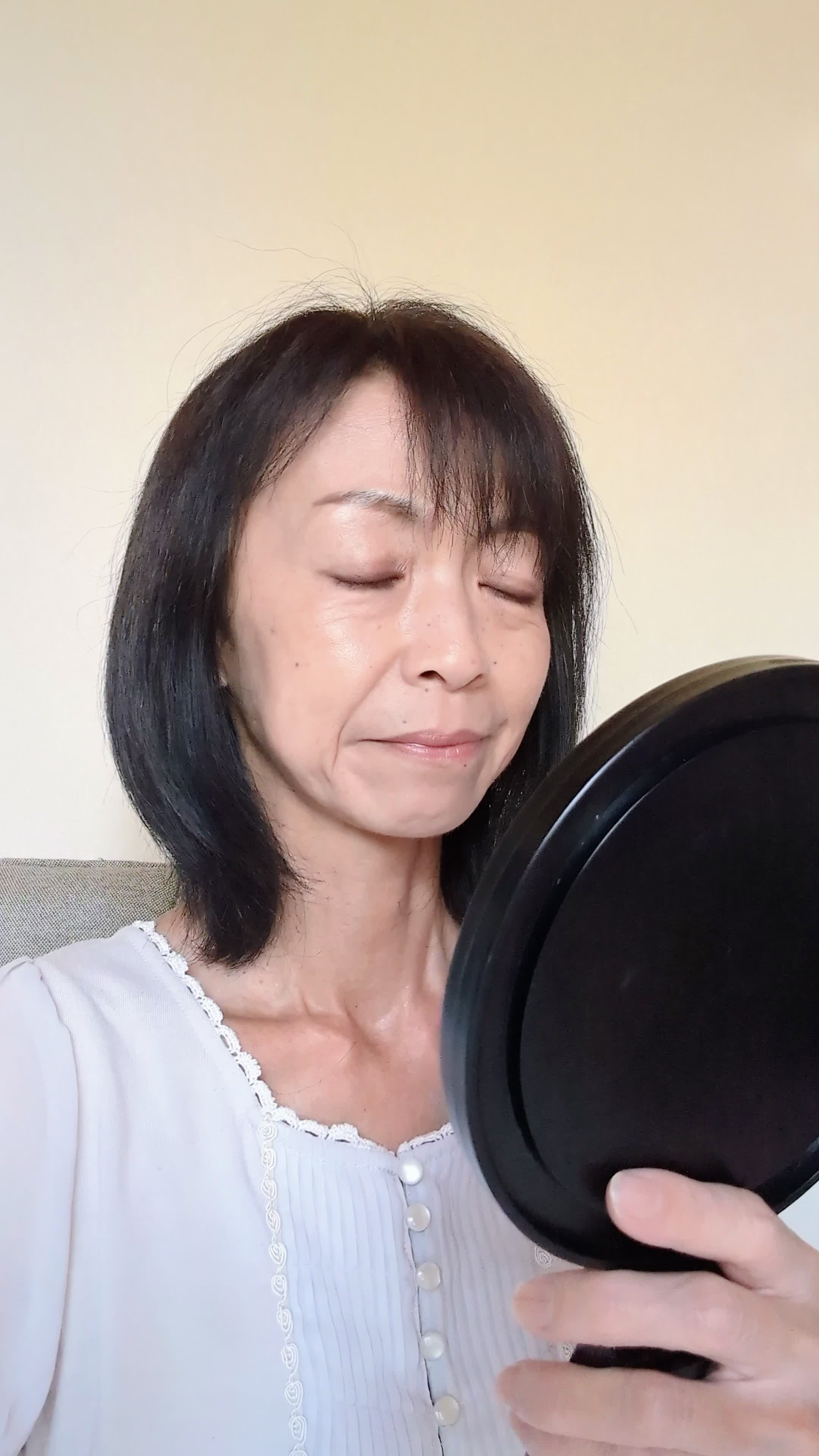 椅子に座り、鏡の前で歯を見つめ、「もう少し整えたい」と悩む表情