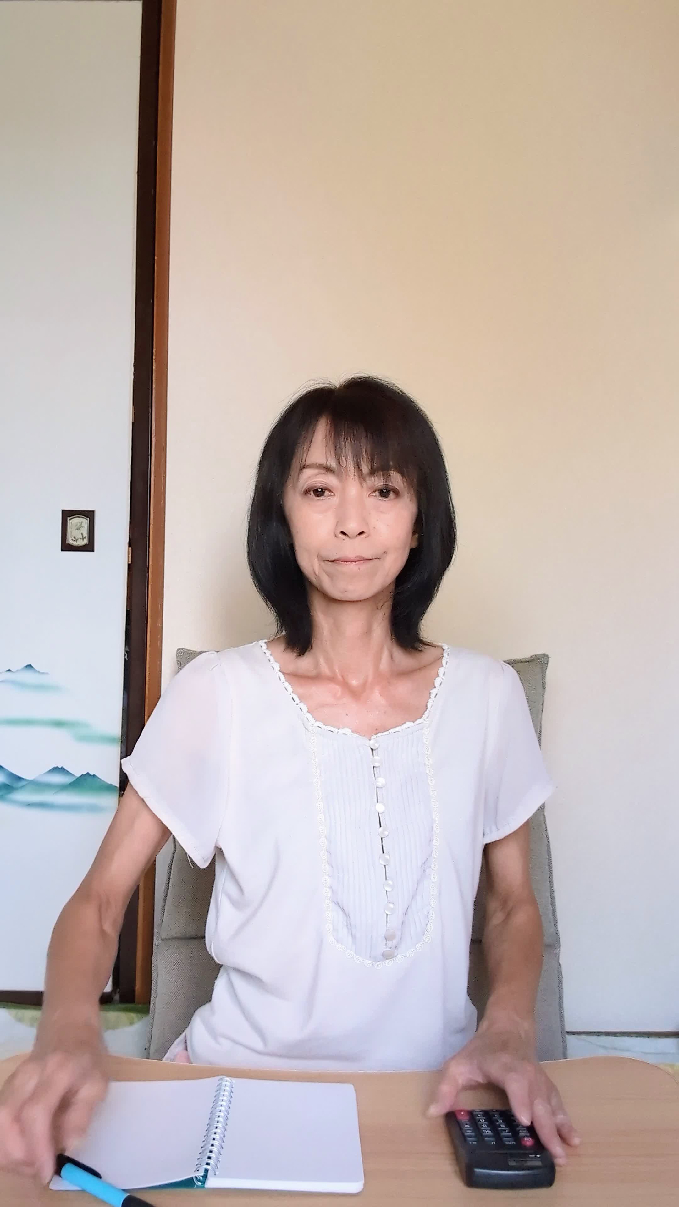 椅子に座り直し、「治療費について調べてみよう」と電卓を操作する動作