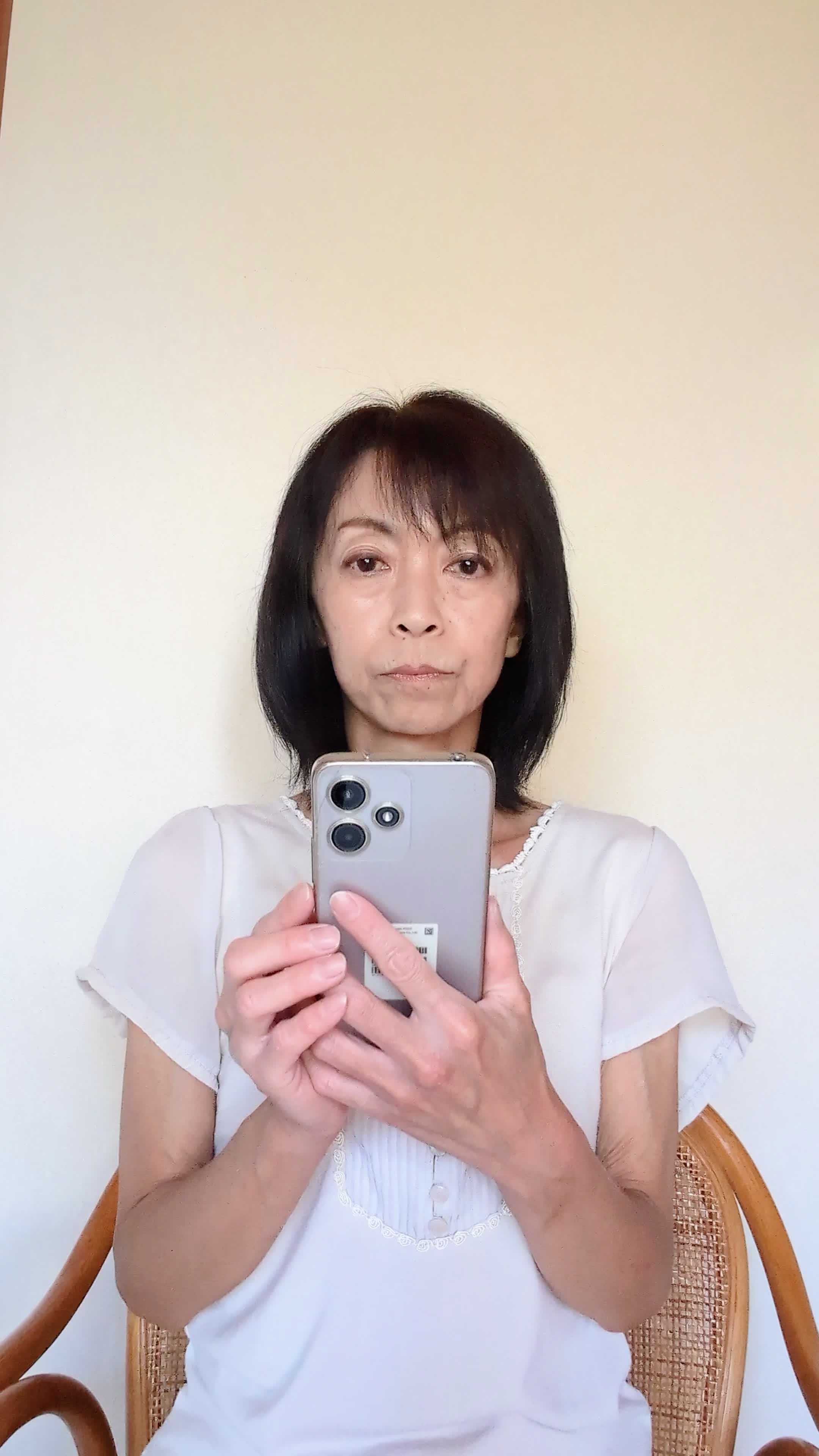 ソファでスマホを見ながら、「矯正の口コミ」を調べて頷く様子