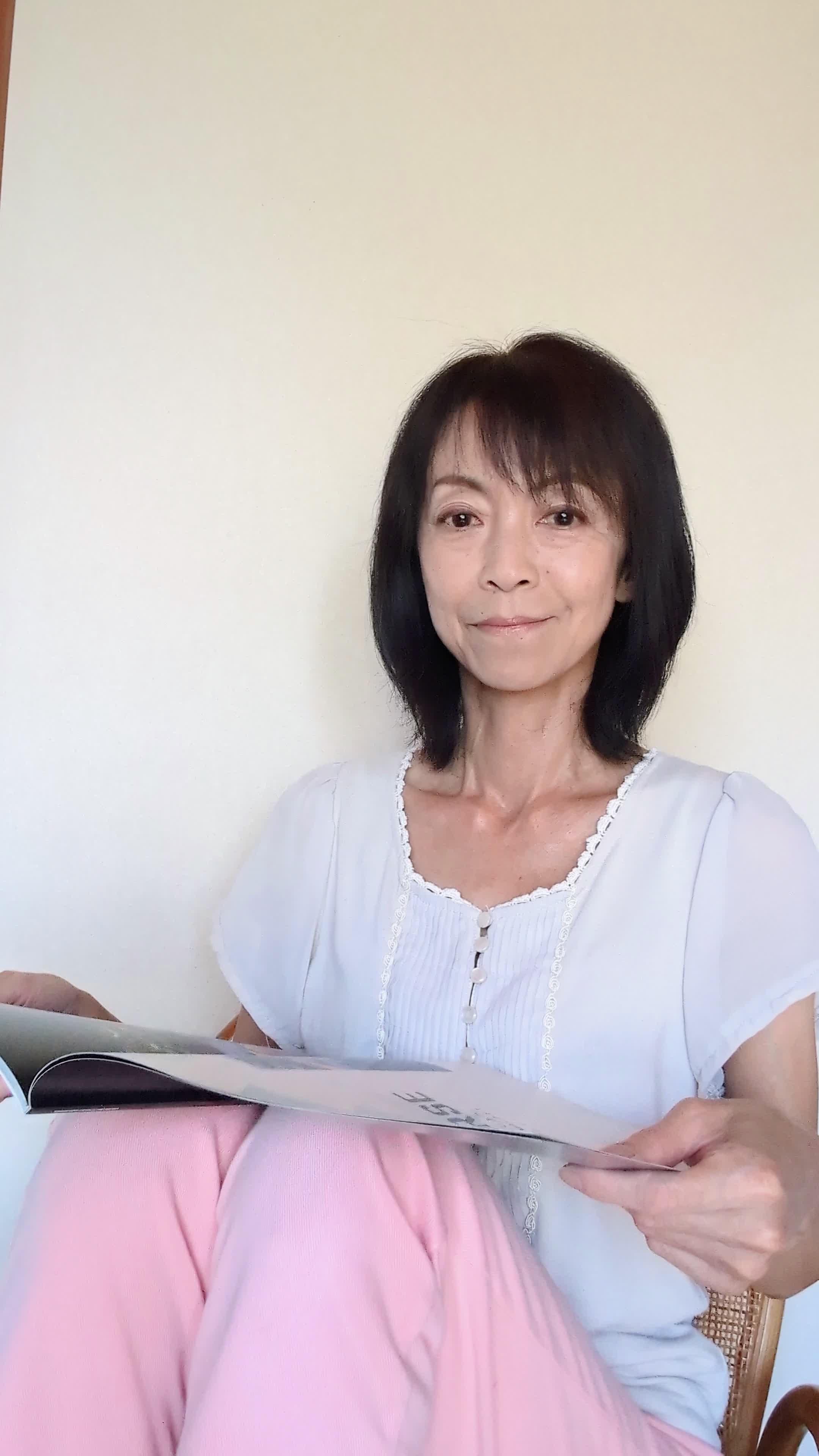 ソファで雑誌を眺めながら、「歯並びの綺麗なモデルに憧れる」微笑む表情