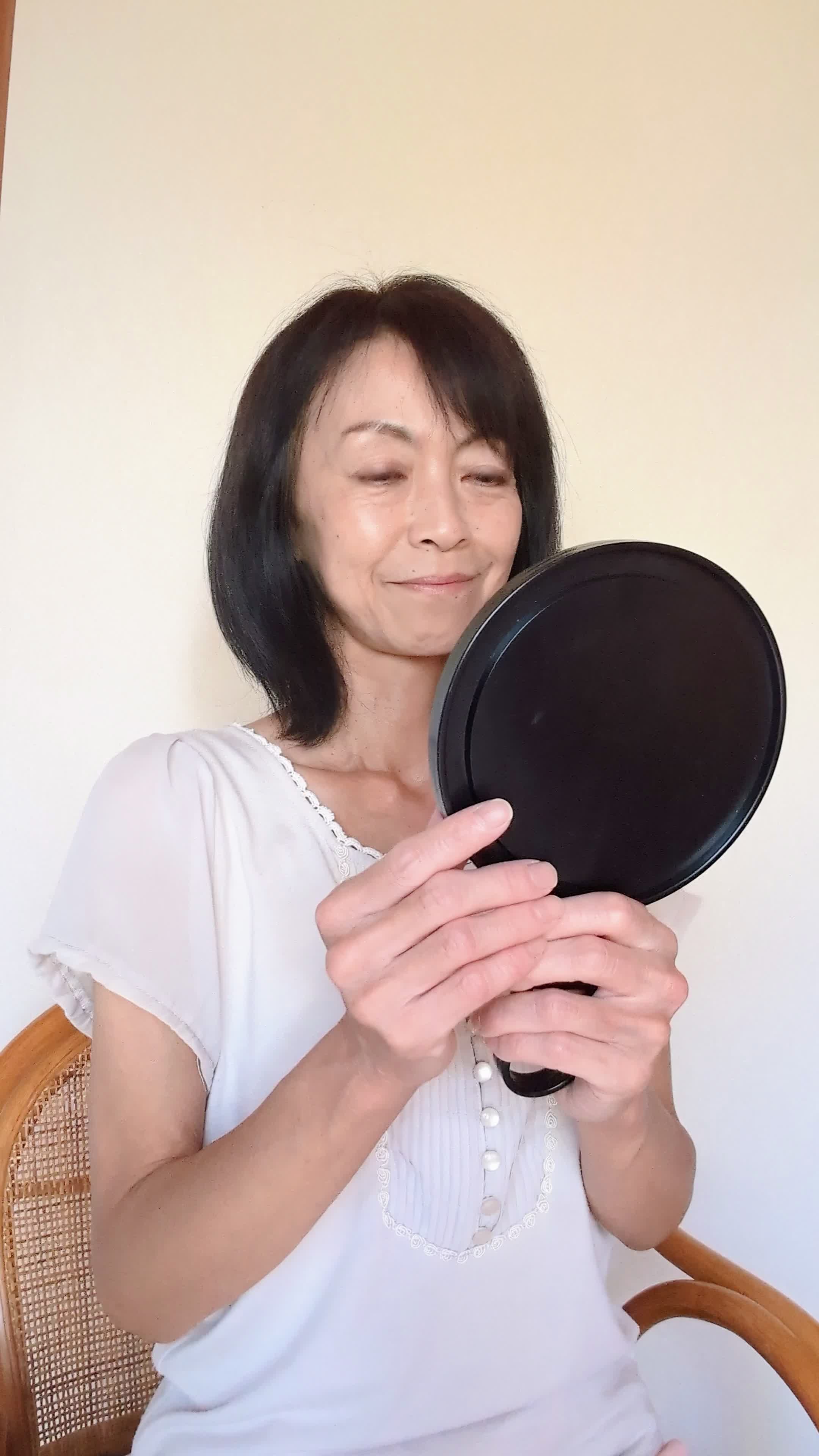 ソファで鏡を見ながら、「矯正後の自分を想像して」期待に胸を膨らませる姿