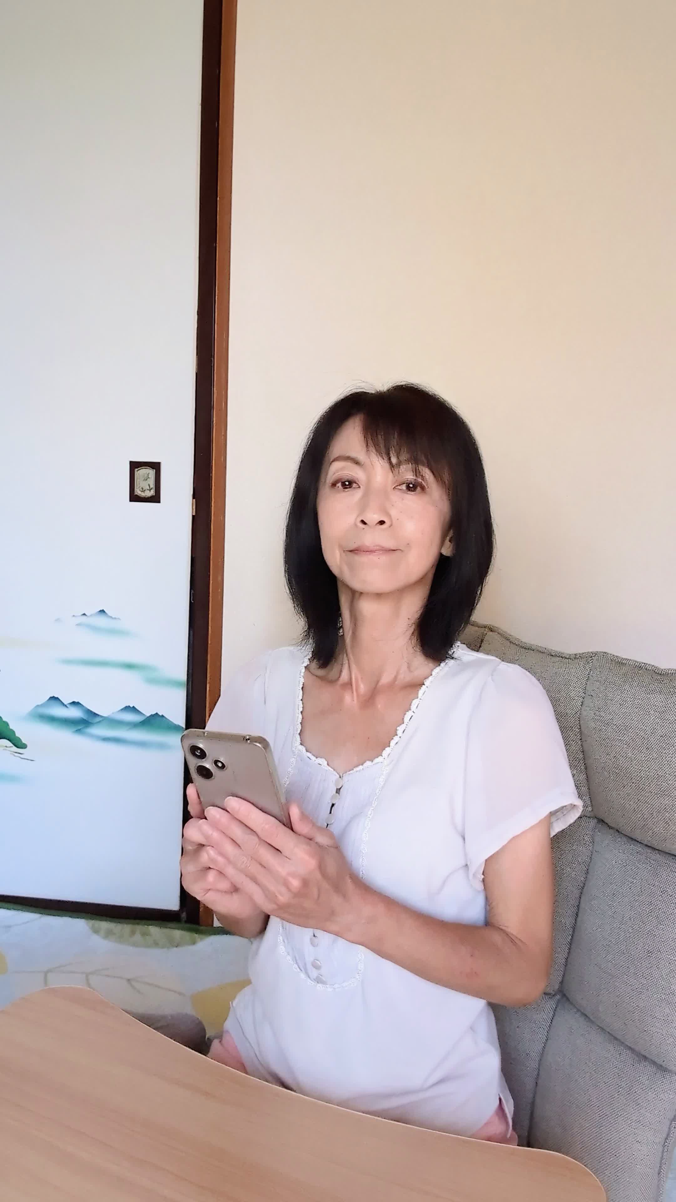 ソファでスマホを置き、「矯正を始める決意を固める」前向きな表情