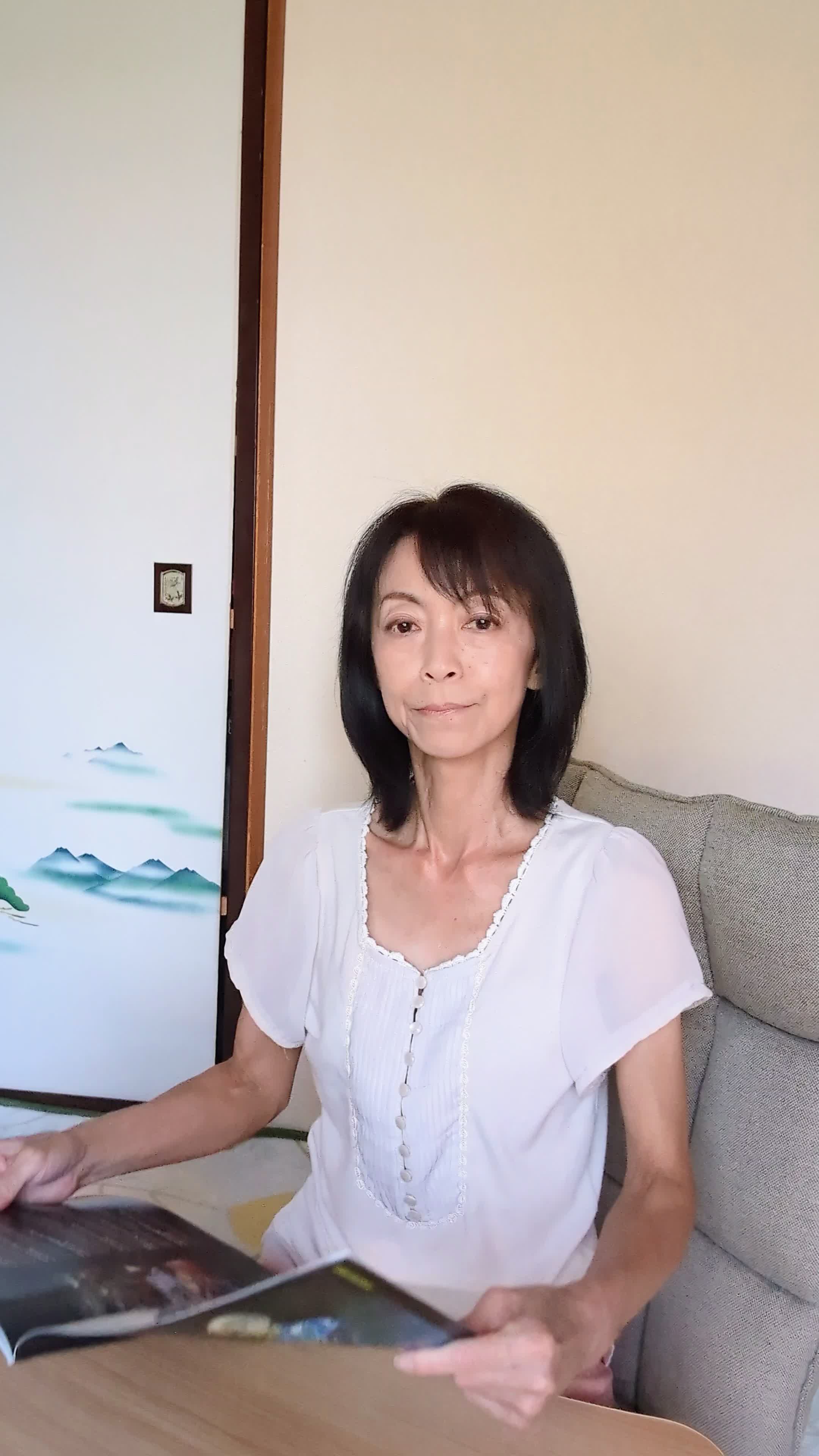 テーブルで矯正治療のカタログを見ながら、「これなら目立たないかも」と安心する表情