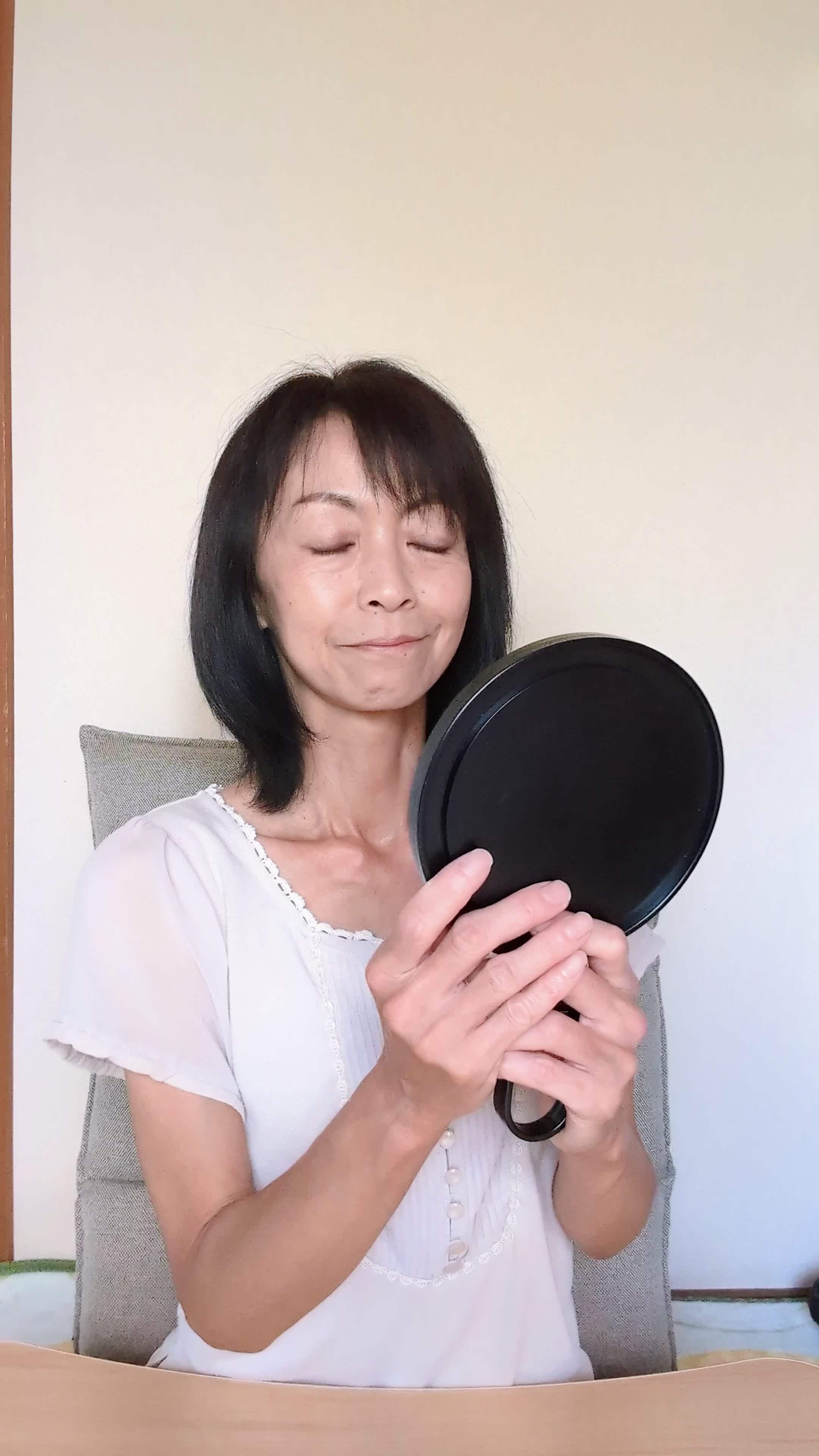 テーブルで鏡を手に取り、「これが治ったらどんな笑顔になるんだろう」と期待する様子