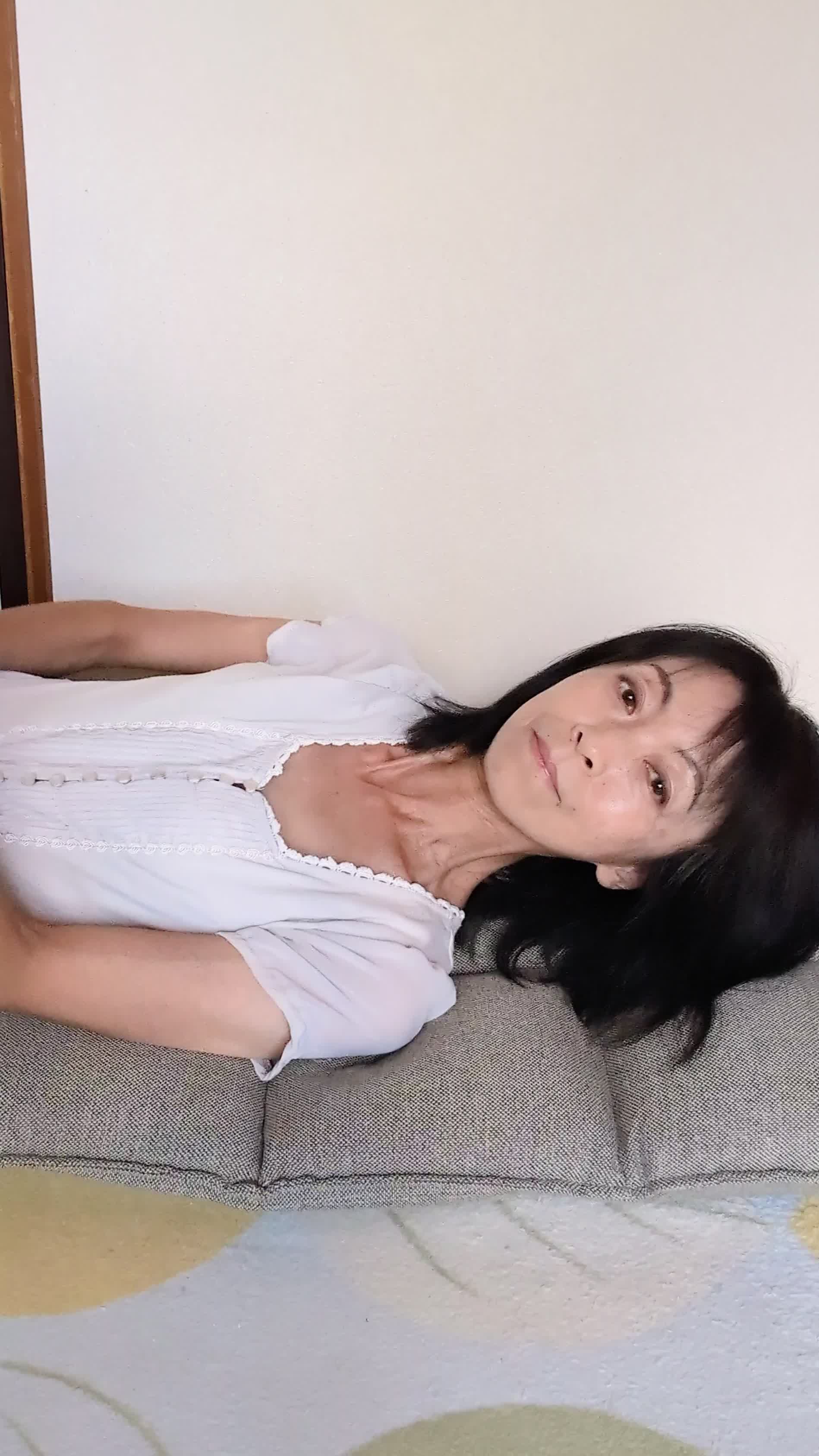 座椅子で横になり、「笑顔がもっと綺麗になるのかな？」と微笑む様子