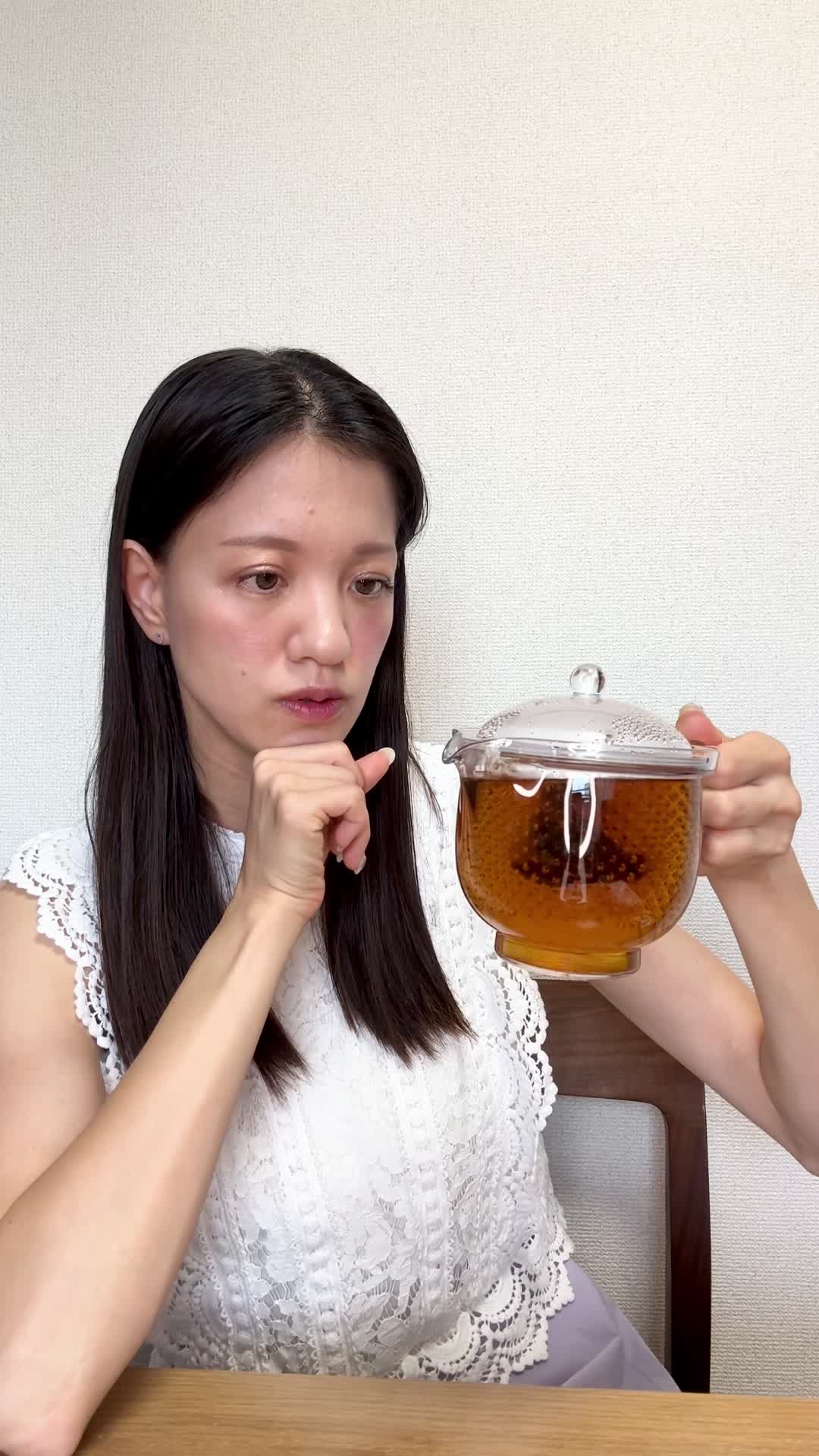 テーブルで飲み物を前に、「これが腸に良いのかな？」と少し戸惑う様子