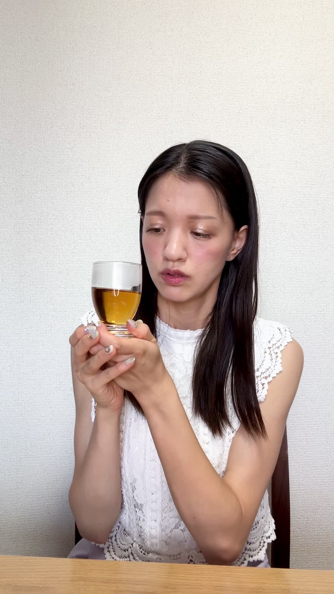 テーブルでカップを手に取り、「腸の不調がこんなに続くとは…」と困った顔をする様子