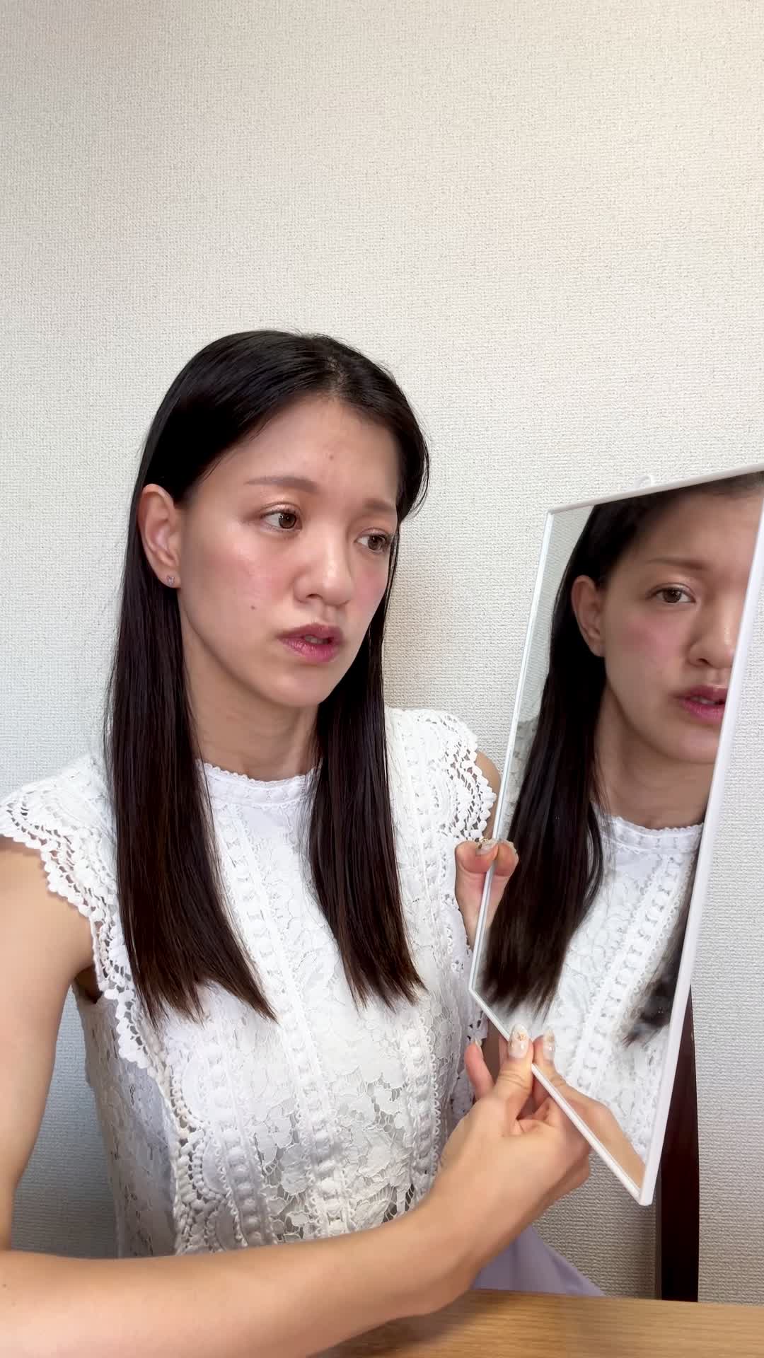 テーブルで鏡を見ながら、「顔色が悪くて腸の不調のせいかも」と気にする様子