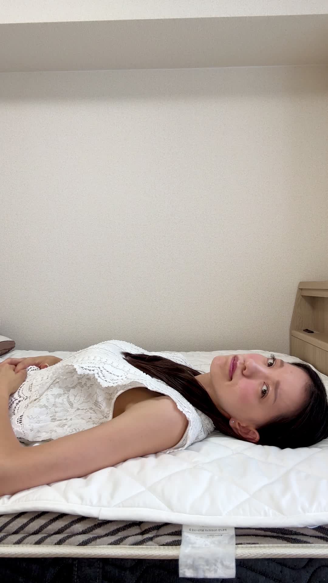 ベッドで横になり、「また便秘が続いている…」と眉をひそめて悩む表情