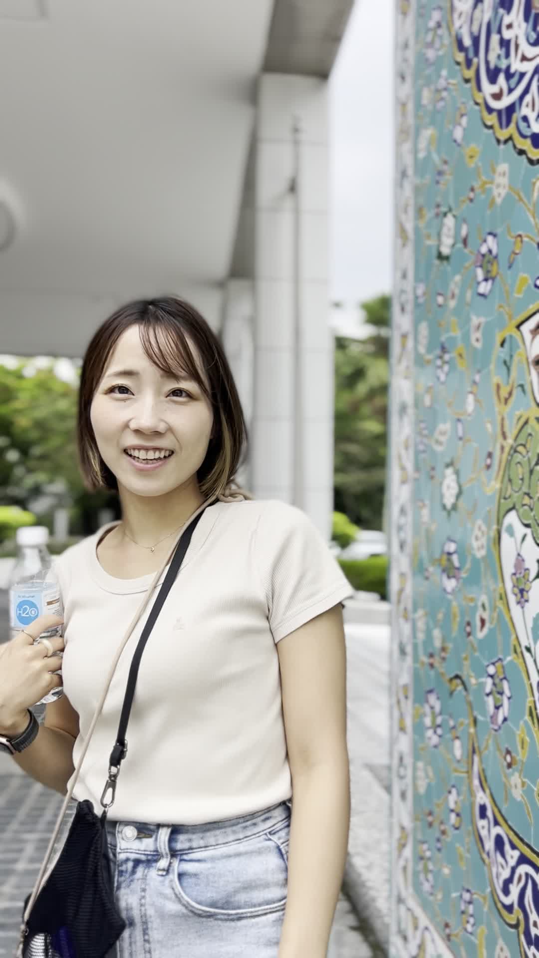 壁の前でピースする様子