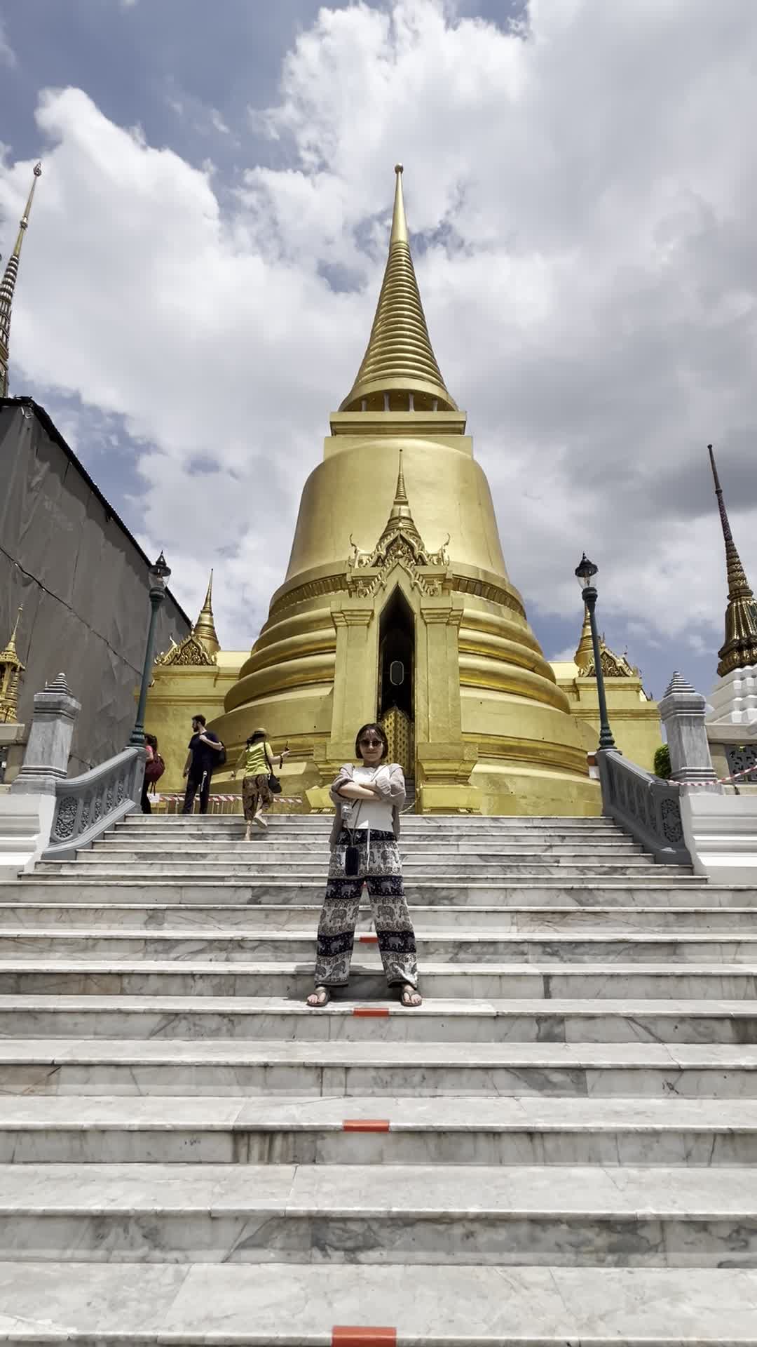 金ぴかの建物の前で腕組みポーズ