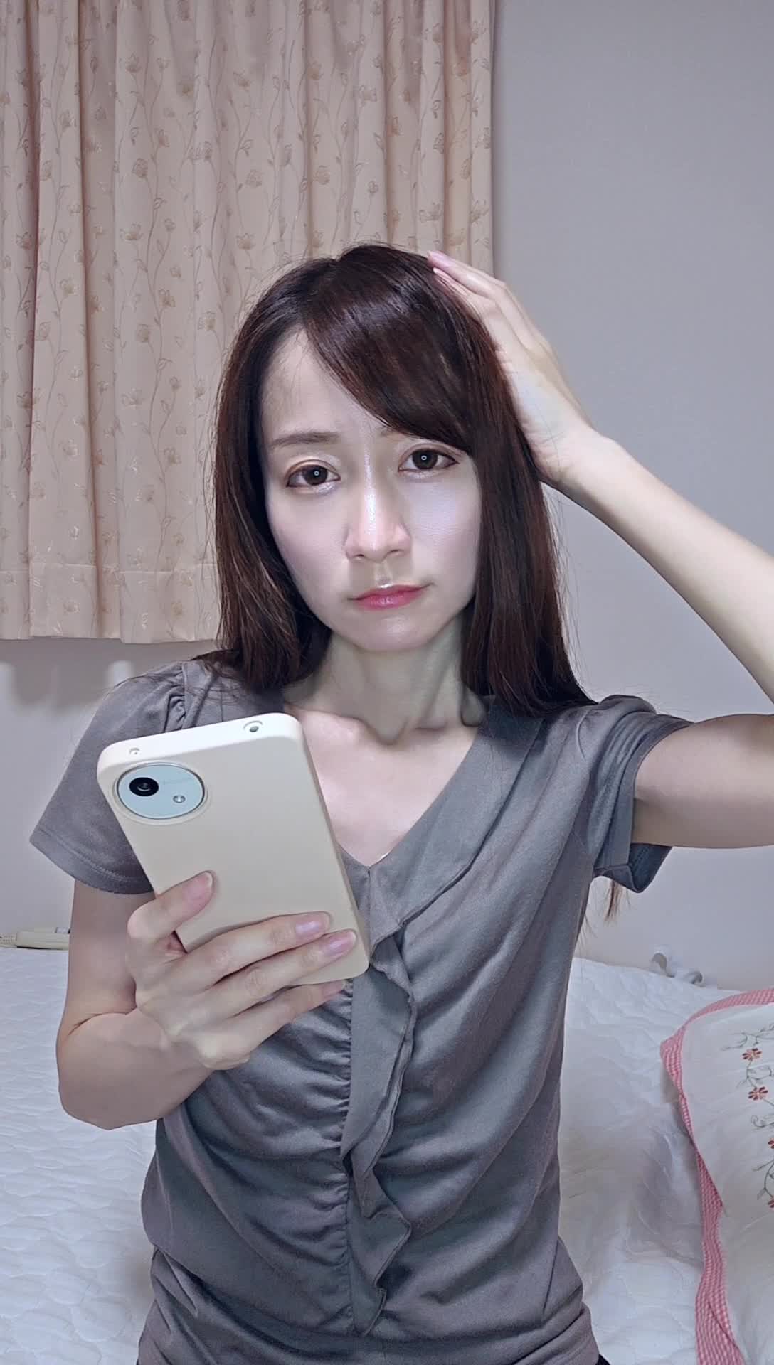 スマホを片手で持ち、もう片手で頭を触りながら考え込む