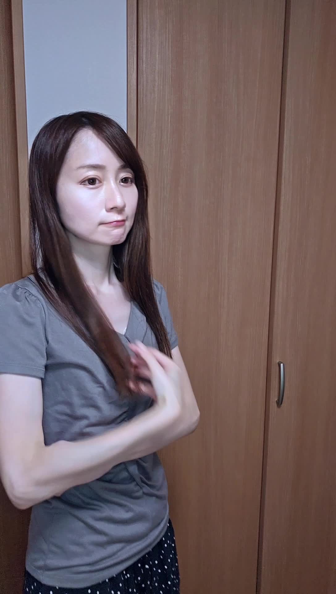 髪を気にしながらリビングで立ち止まり、少し困った表情を浮かべる