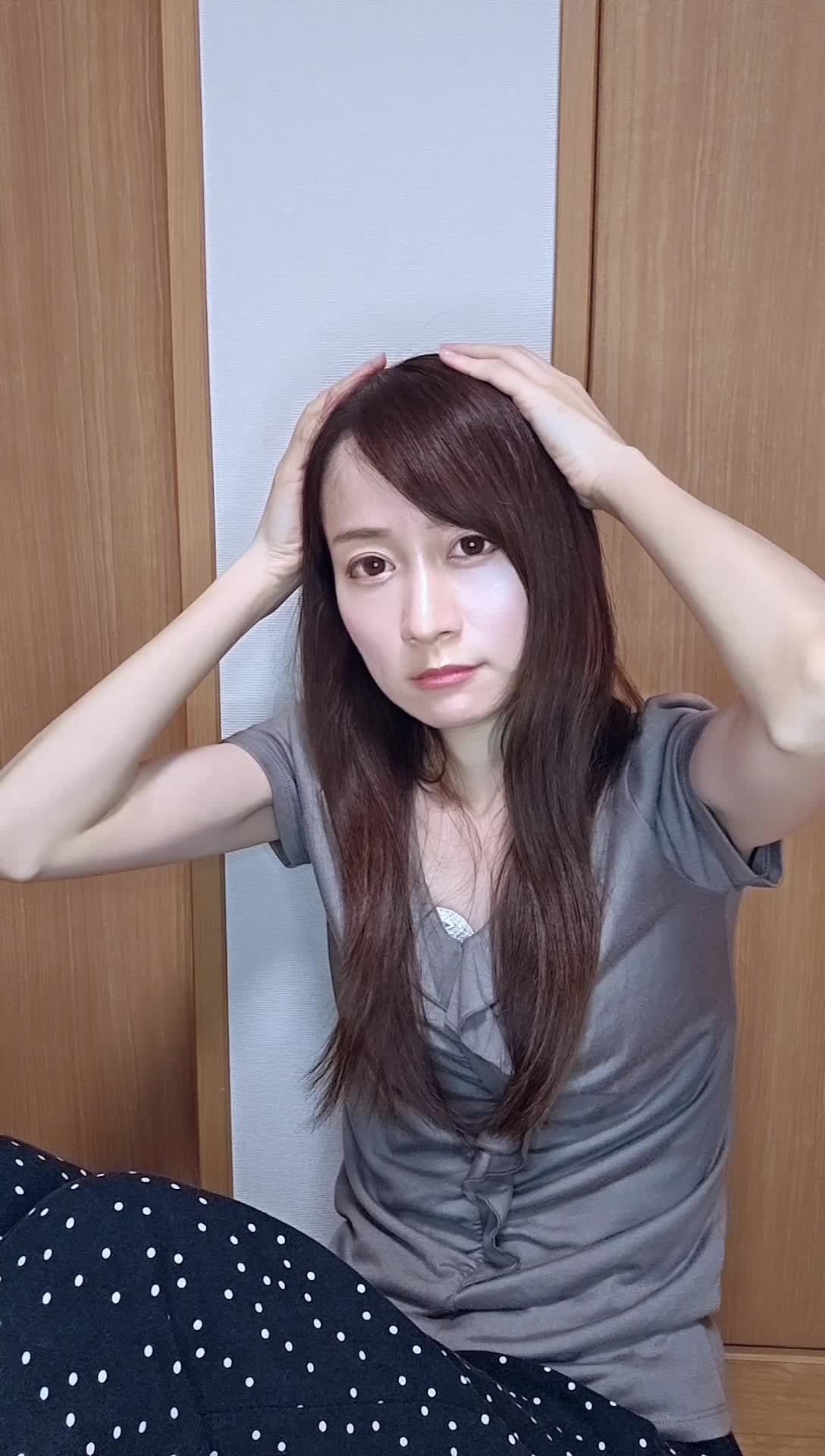 壁に寄りかかり、頭に手を当てて考え込む仕草をする