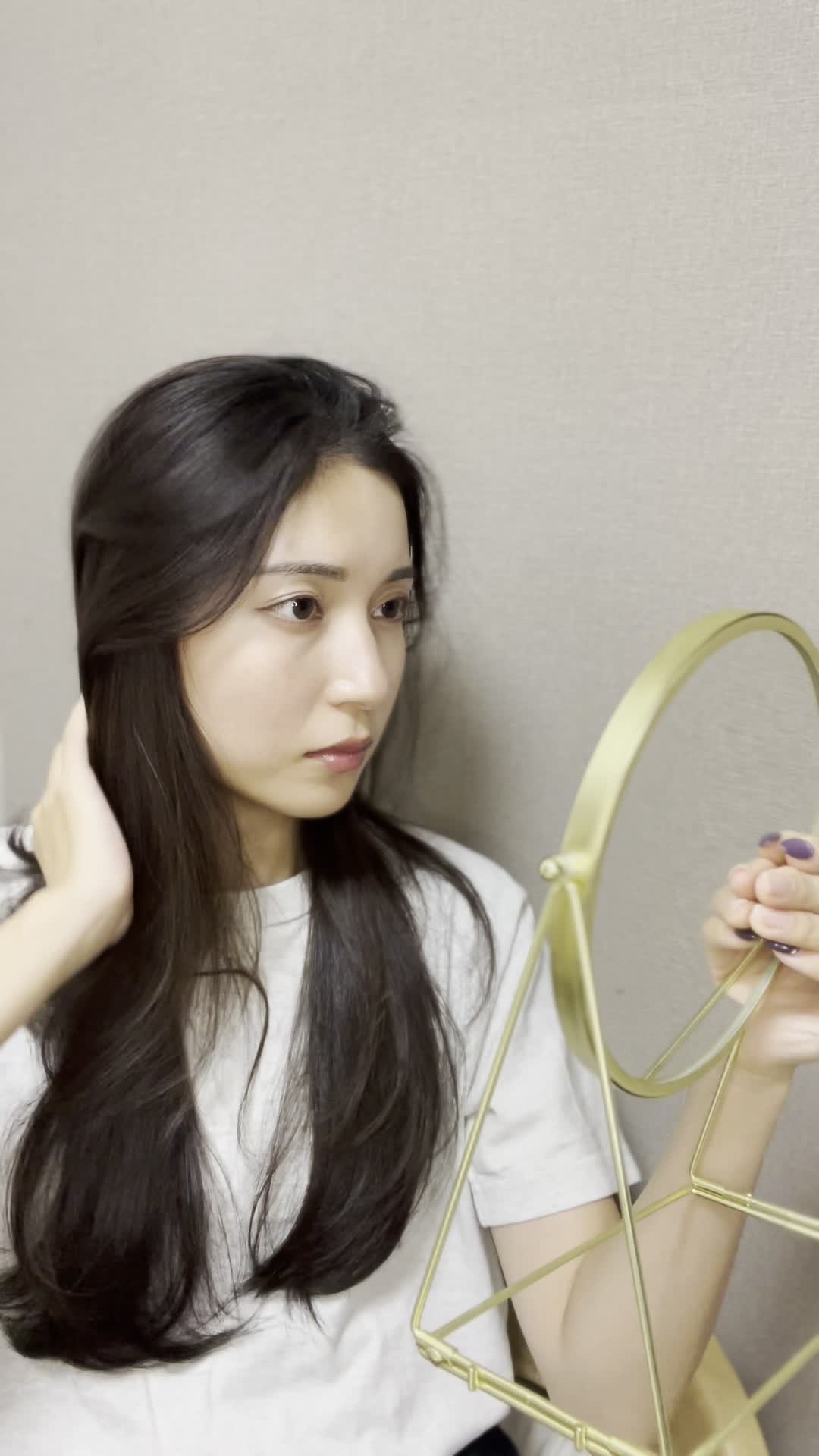 鏡の前で髪を軽くかき上げながら、自分の姿を確認する