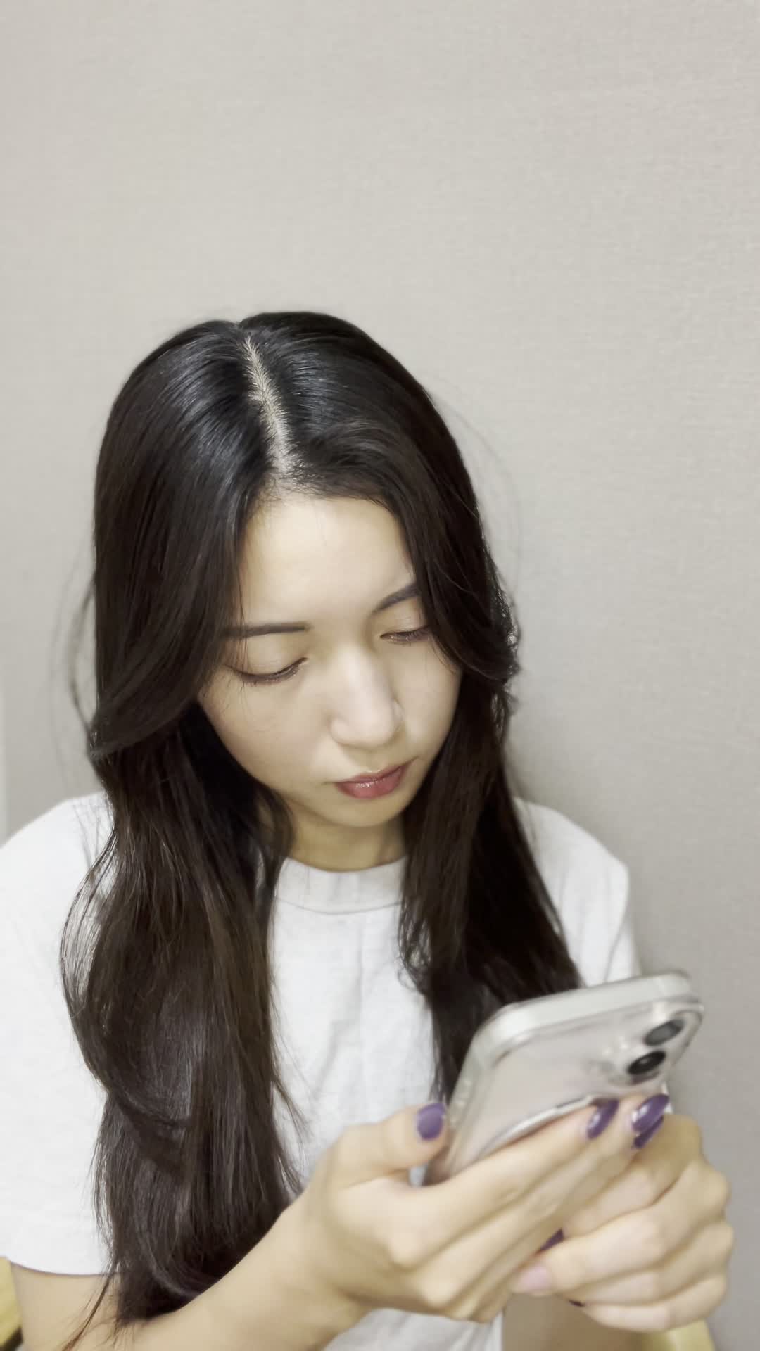 スマホを持ったまま、少し俯き加減で考え込む仕草をする