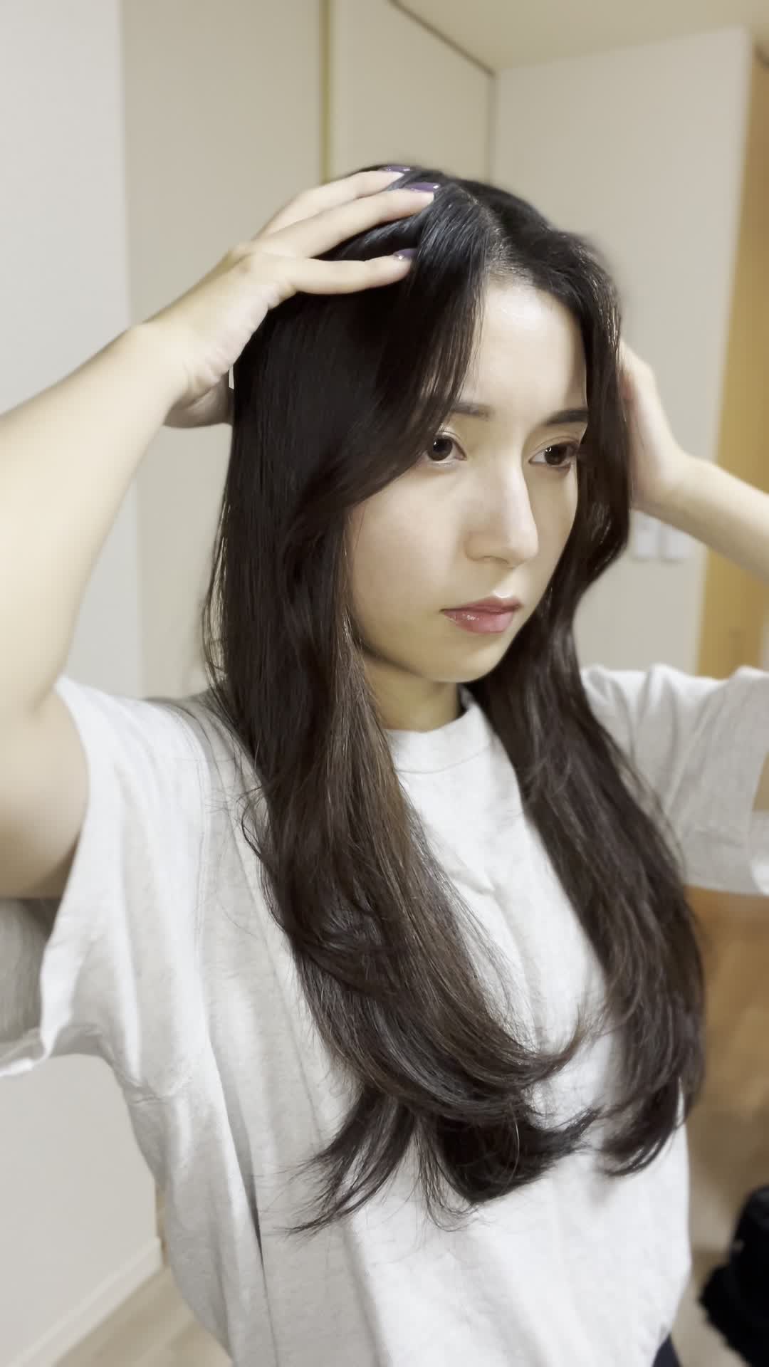 頭皮を指で押さえながら、真剣に自分を見つめている表情をする