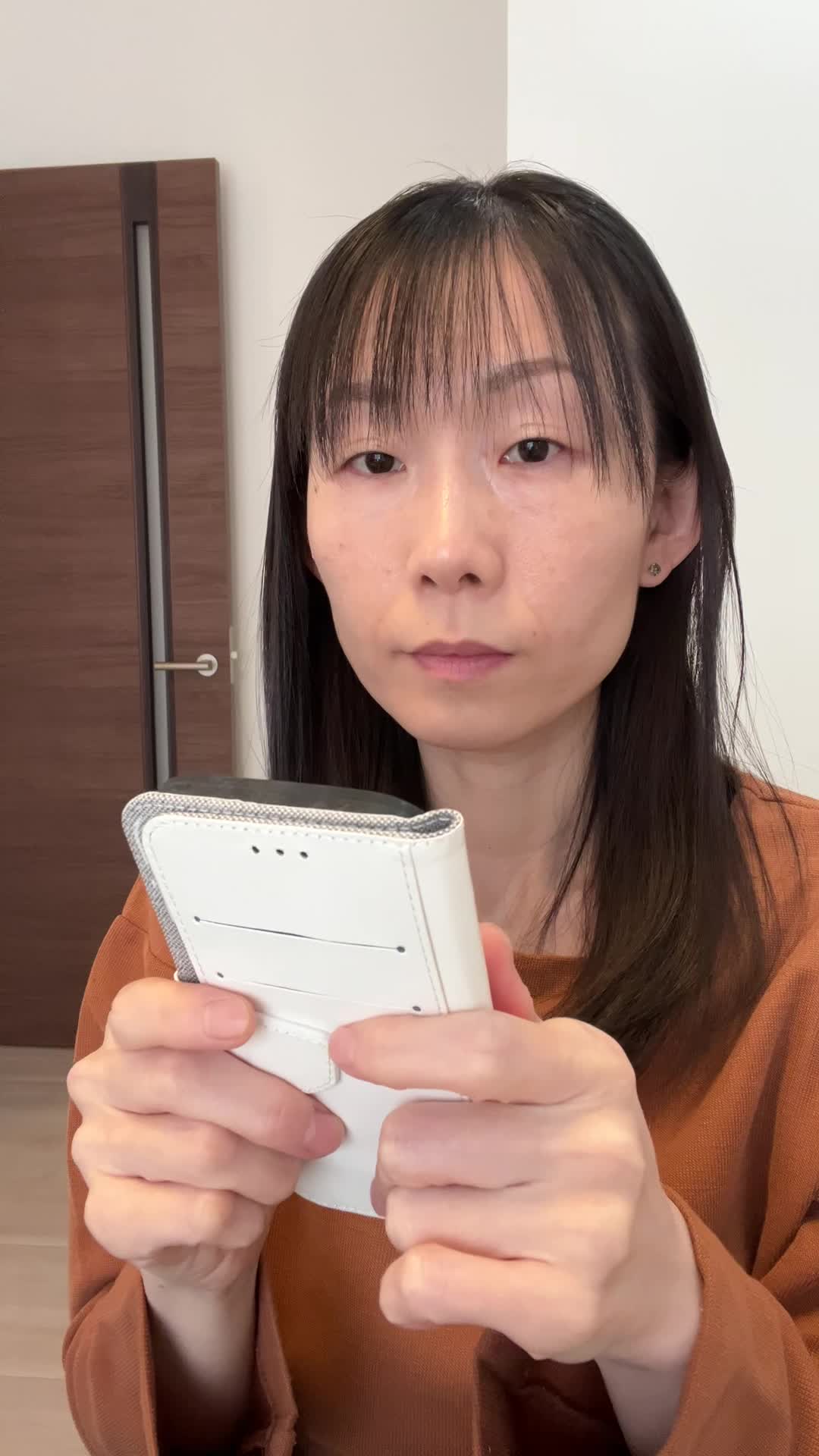 スマホを両手で持ち、AGAクリニックの評判をじっくり確認している様子