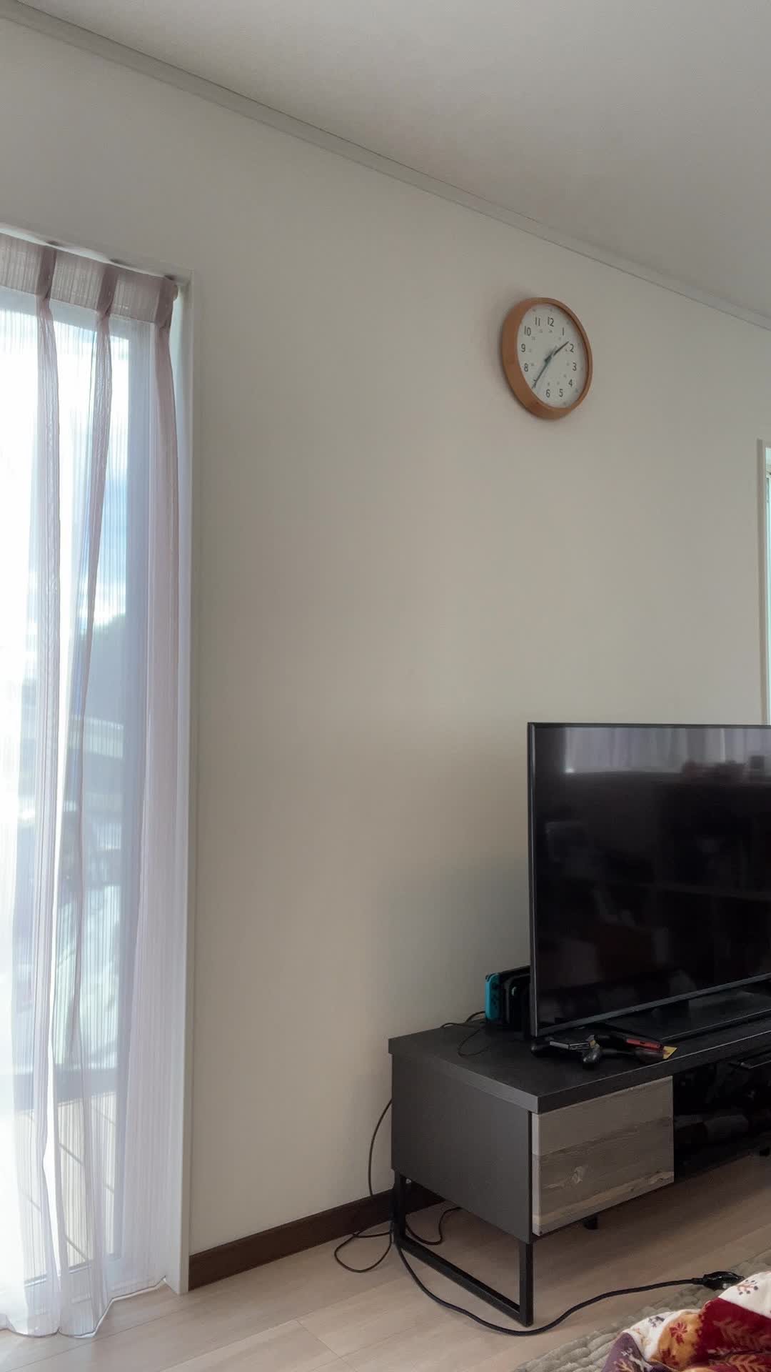 髪を気にしながらリビングで立ち止まり、少し困った表情を浮かべる