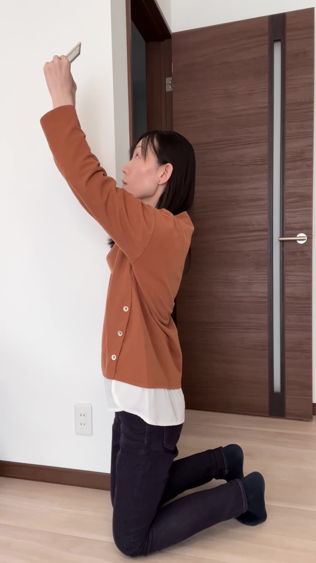 床に膝をつき、鏡を持って頭頂部を確認する仕草をする