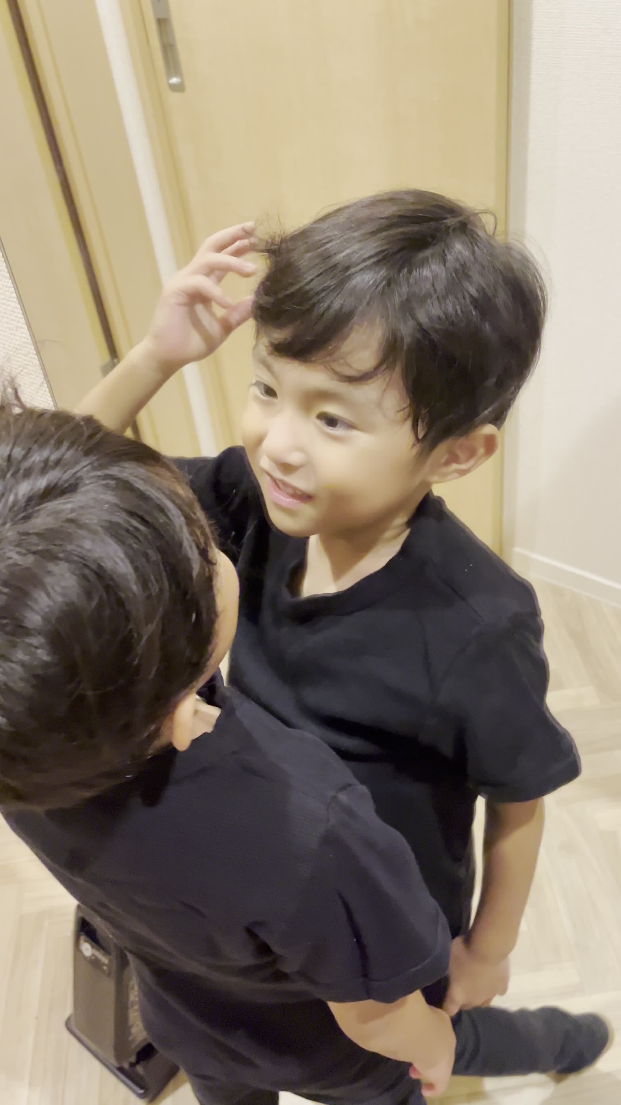 鏡に向かって微笑み、髪の状態をチェックしている姿を見せる